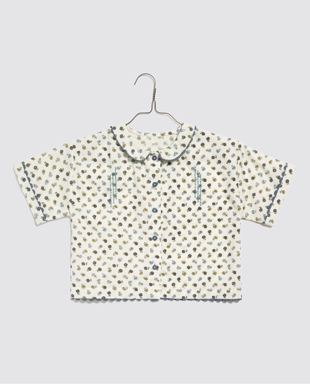 Short-sleeve girls blouse made from organic cotton with a vintage-inspired daisy floral print and delicate scalloped edges, designed for sustainable children's clothing.