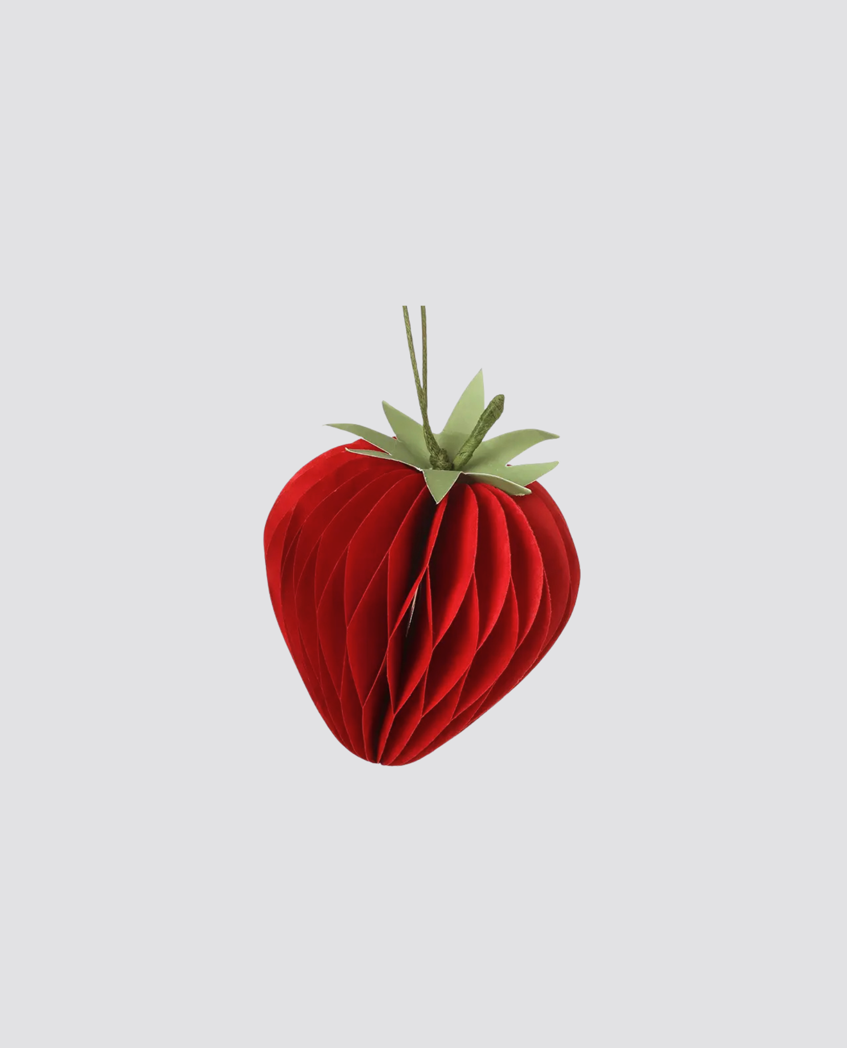 Red paper strawberry decoration with green leaves, crafted with natural style, perfect for adding a charming, vintage touch to a slow, ethical children's clothing brand display.