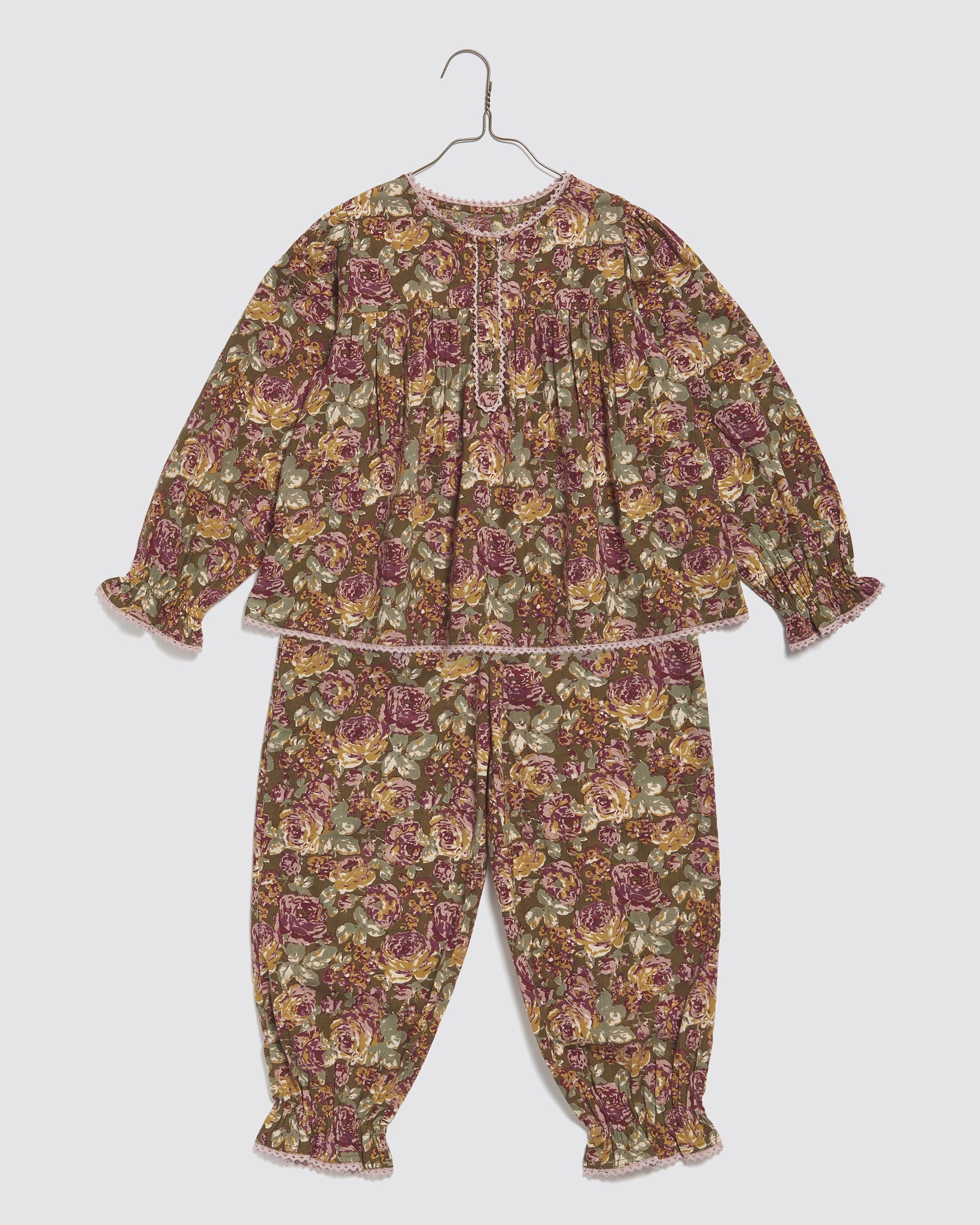 Vintage style children's pyjama set in organic cotton featuring a green floral pattern with delicate lace trim, designed for comfort and sustainability.