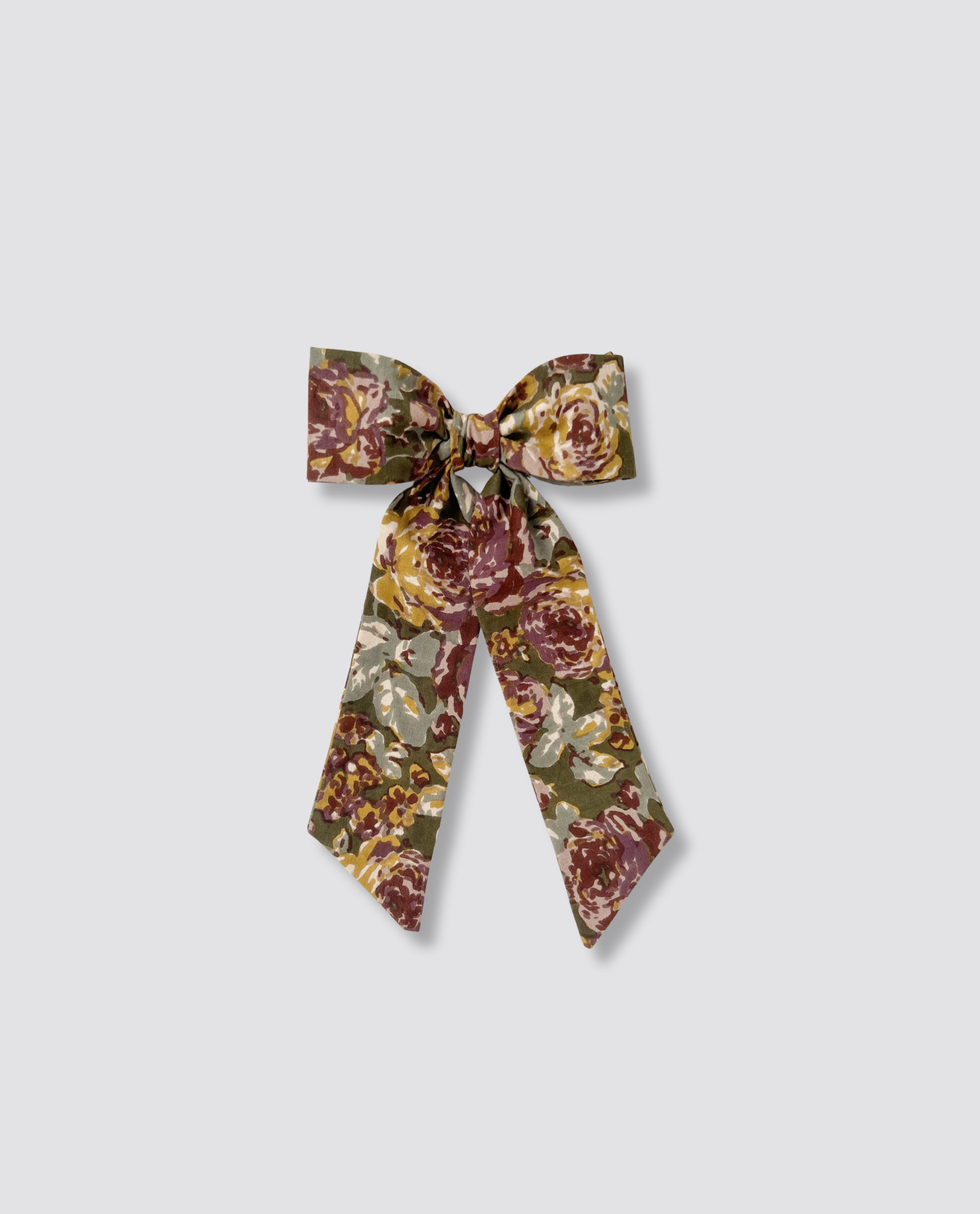 Vintage-inspired floral fabric bow clip in muted earthy tones, crafted from natural cotton for a sustainable and ethically made children's accessory.