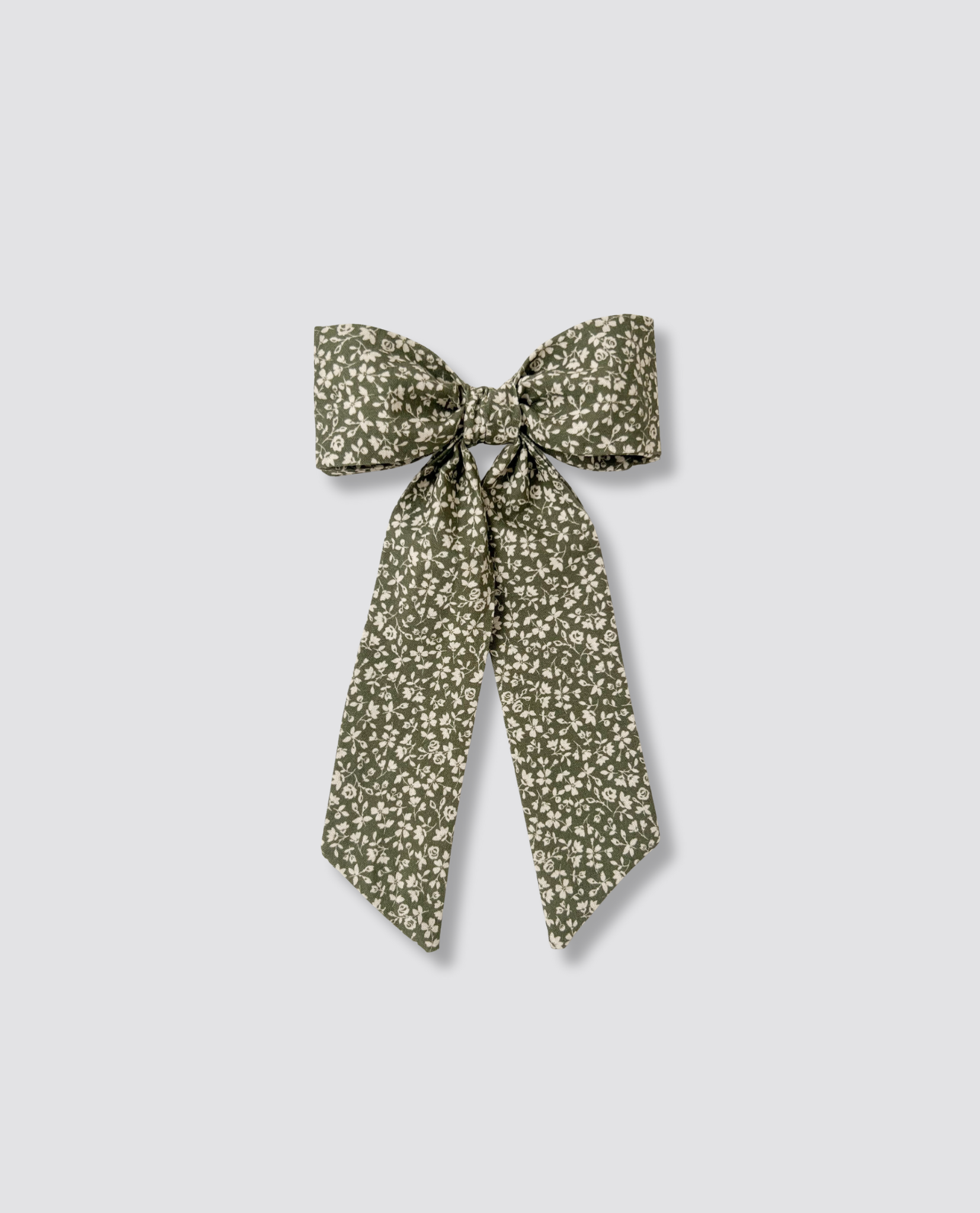 Retro-style bow clip with vintage floral pattern in natural muted green and cream tones, designed for children with sustainable organic materials and ethical craftsmanship.