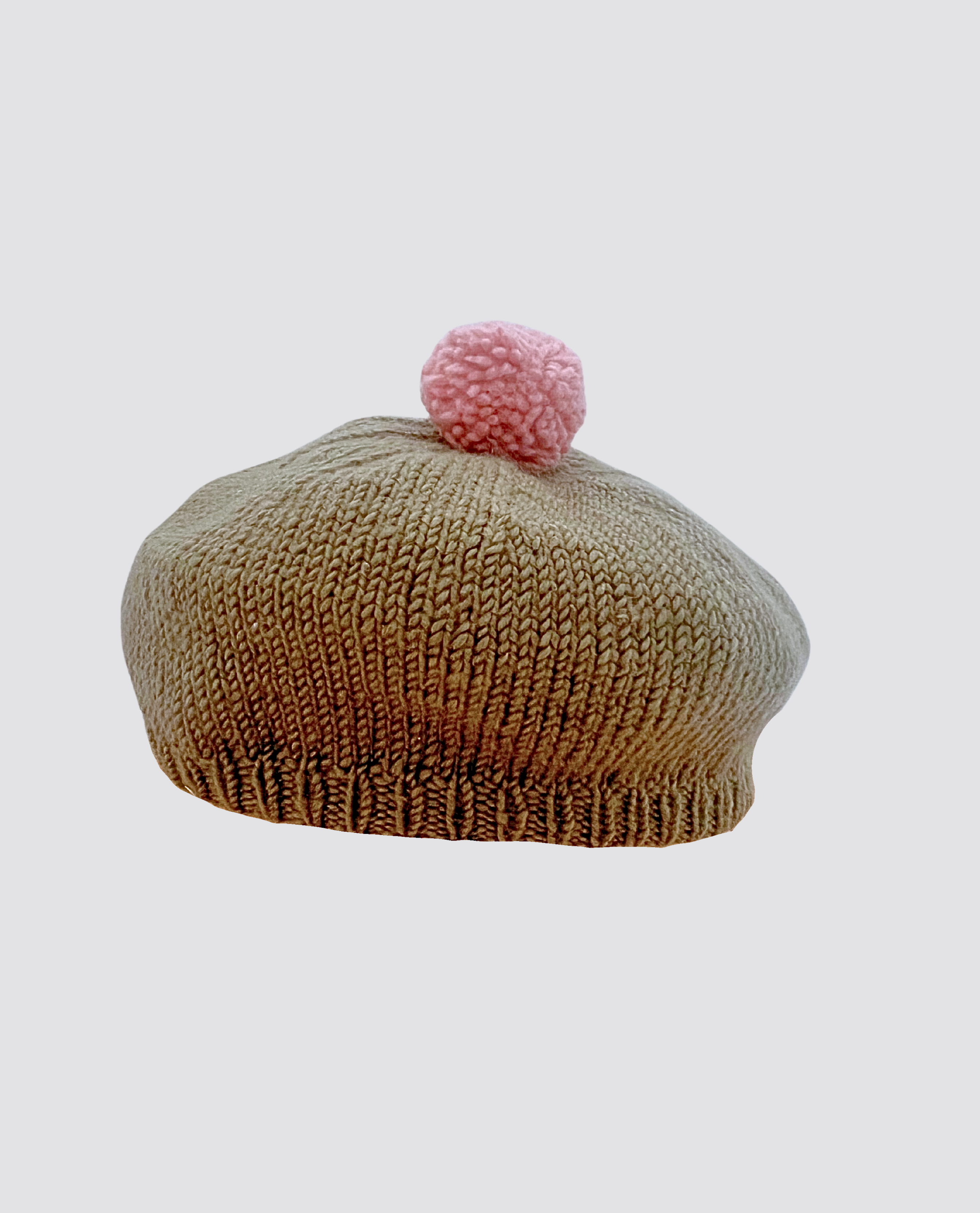 Hand-knitted green merino beret for kids featuring a soft pink pompom, crafted with natural materials in a vintage style, perfect for sustainable children's clothing.