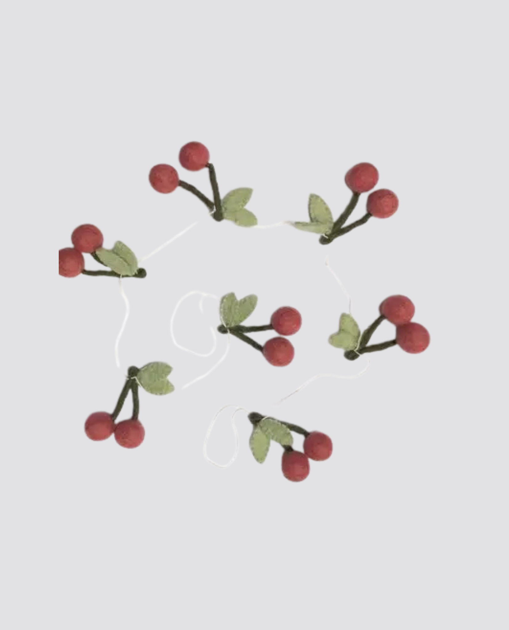 Red felt cherry garland with green leaves made from natural materials, perfect for adding a vintage, organic touch to children's spaces or clothing displays.