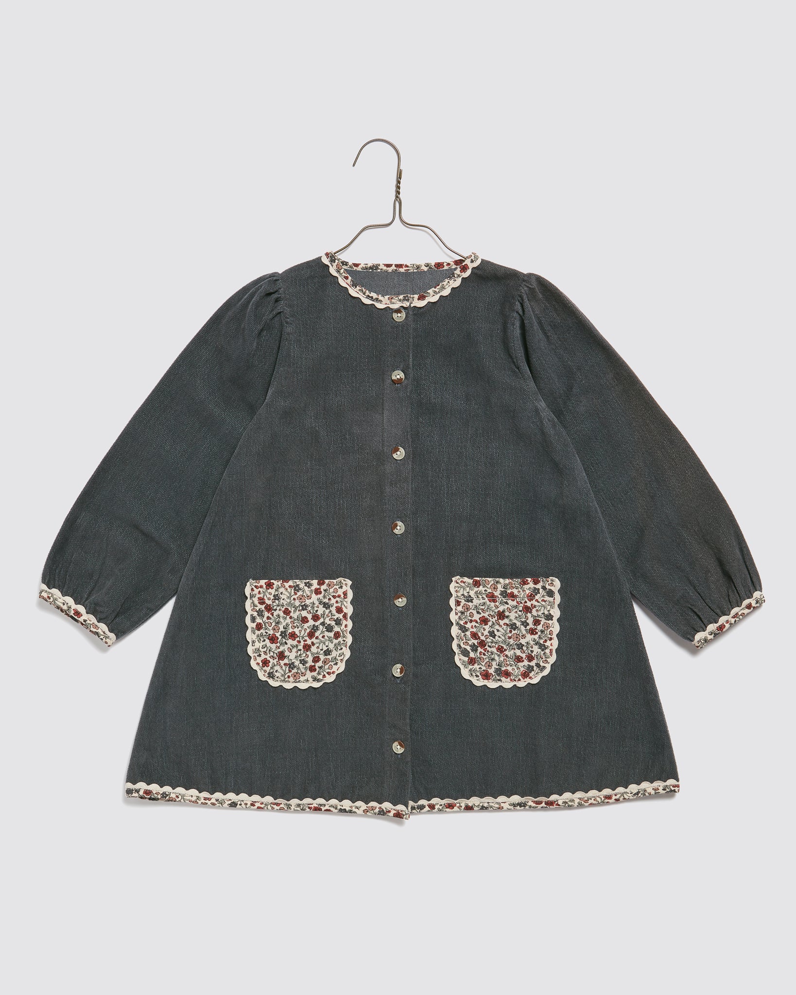 Vintage style girls' dress in dark velvet with long sleeves, featuring floral patterned pockets and delicate lace trim, made from organic cotton for sustainable kids clothing.
