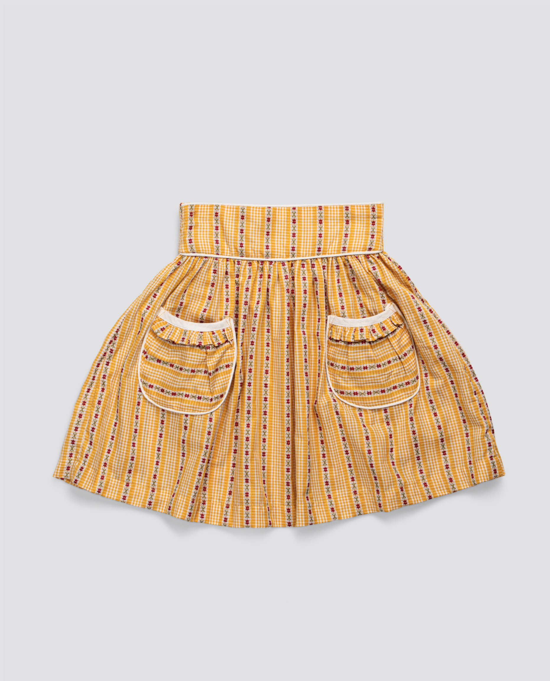 Yellow floral patterned organic cotton skirt for girls featuring vintage style and ethical, sustainable design with two front pockets.