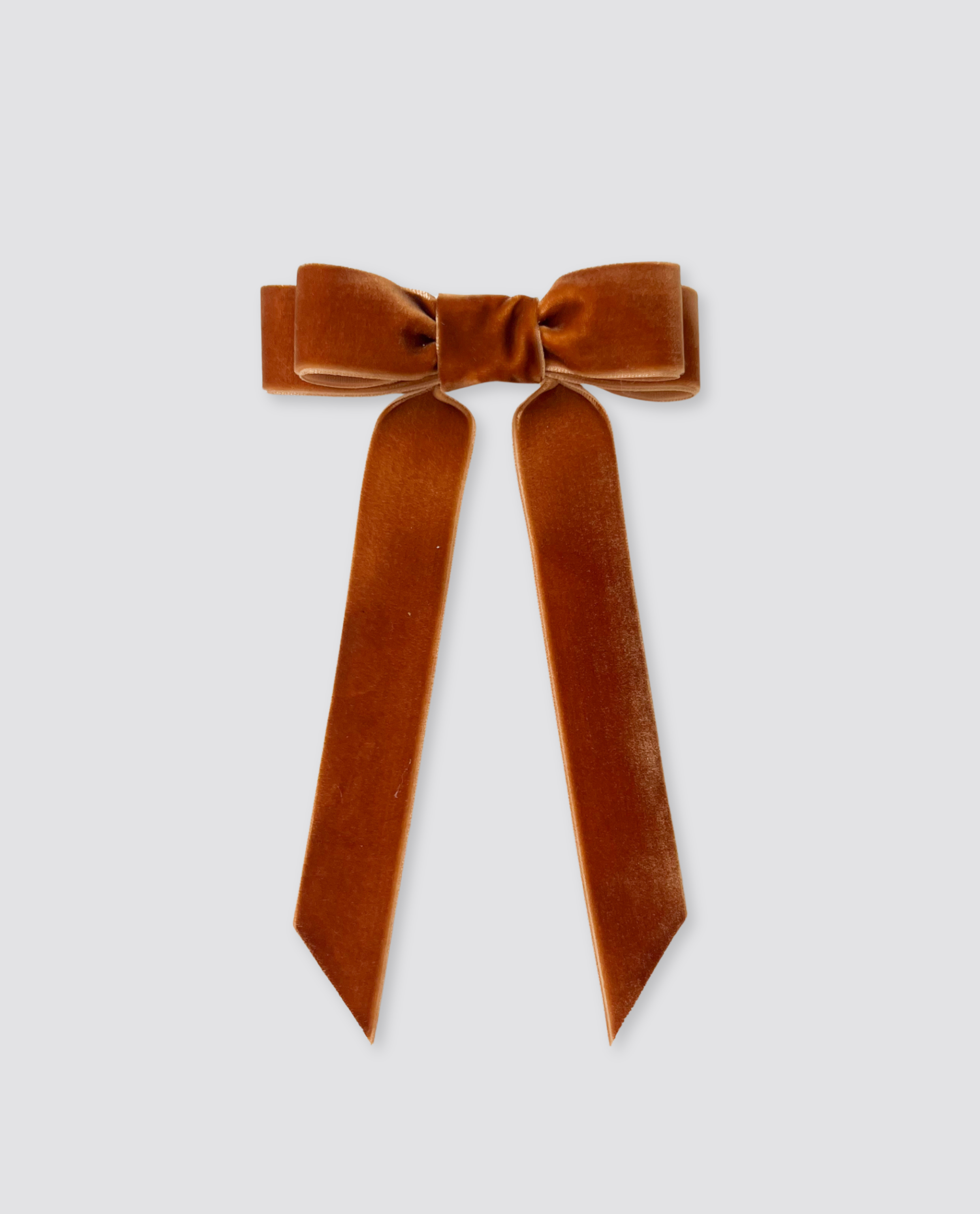 Chestnut-colored velvet hair bow with long tails, designed in a retro style, perfect for adding a vintage touch to girls' sustainable and ethically made clothing.