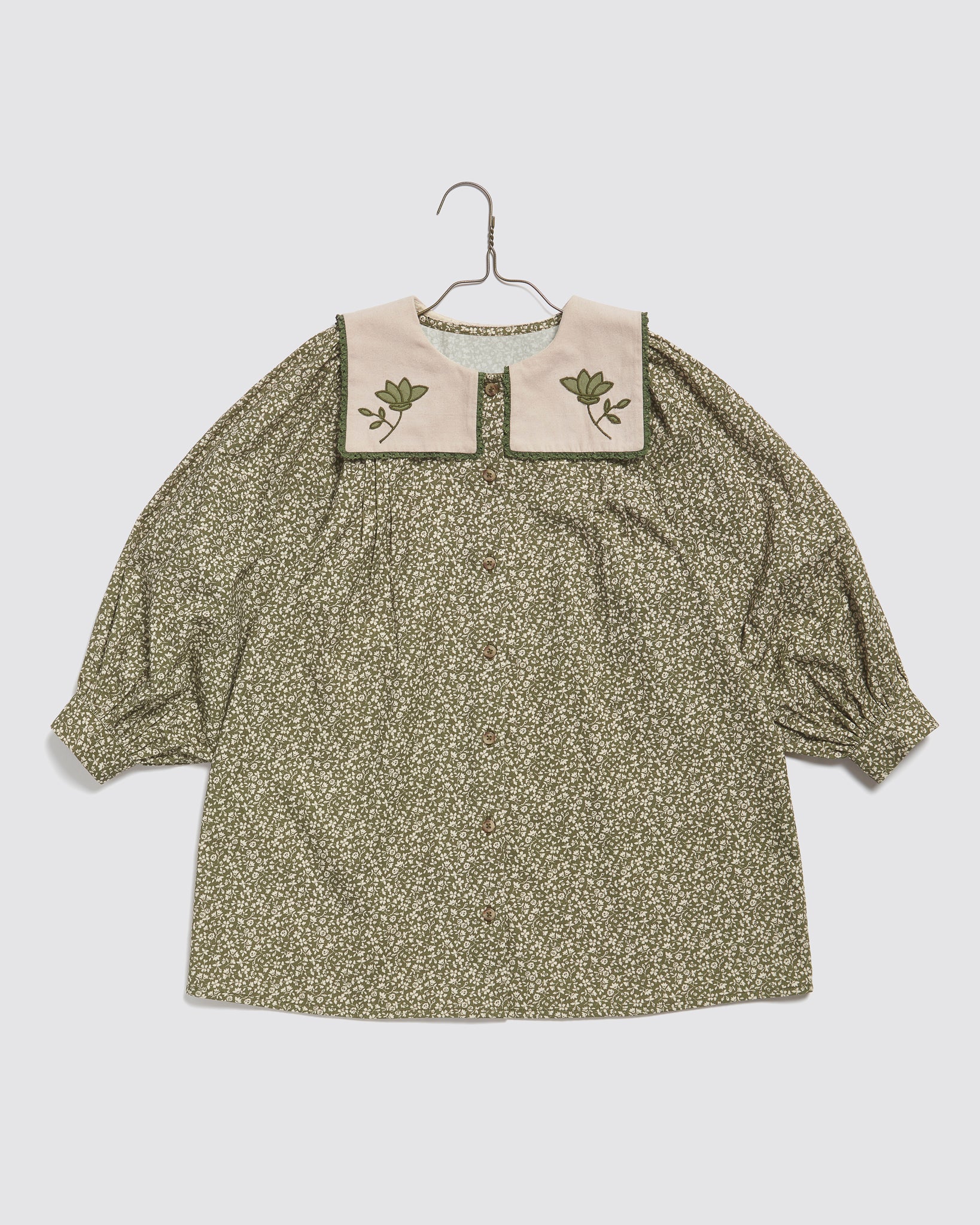 Girls vintage-style green floral dress made from organic cotton with a soft contrasting collar featuring floral applique, designed with sustainability and ethical values.