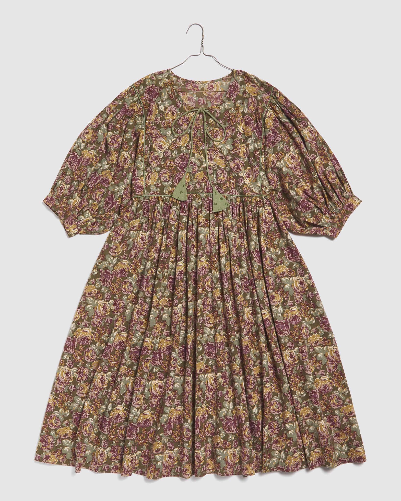 Vintage style ladies dress in green and pink floral pattern made from organic cotton, featuring puffed sleeves and a tie neckline, designed with natural, ethical materials.