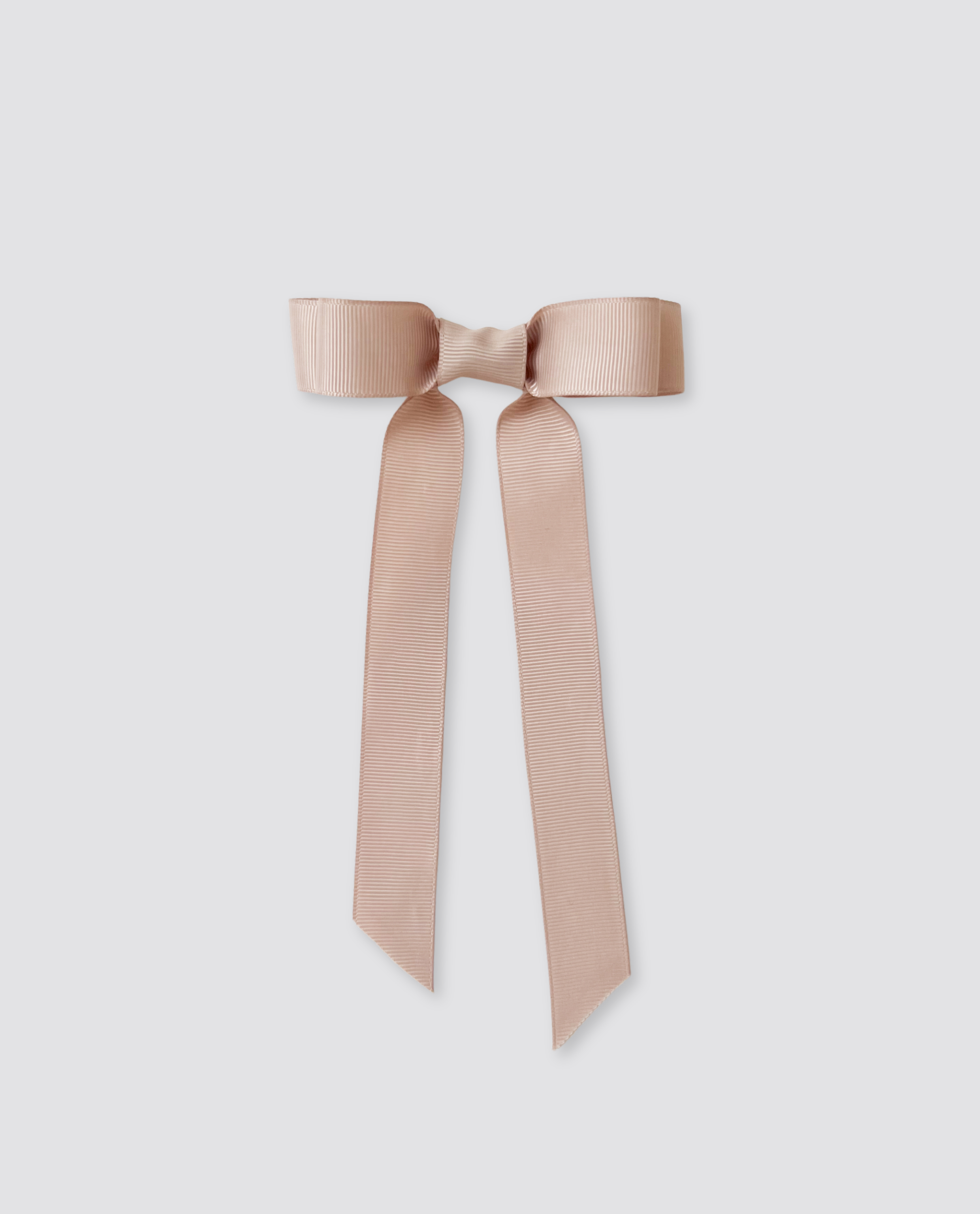 Beige grosgrain hair bow with long tails, designed in a vintage style, perfect for kids, made with natural and sustainable materials reflecting ethical craftsmanship.