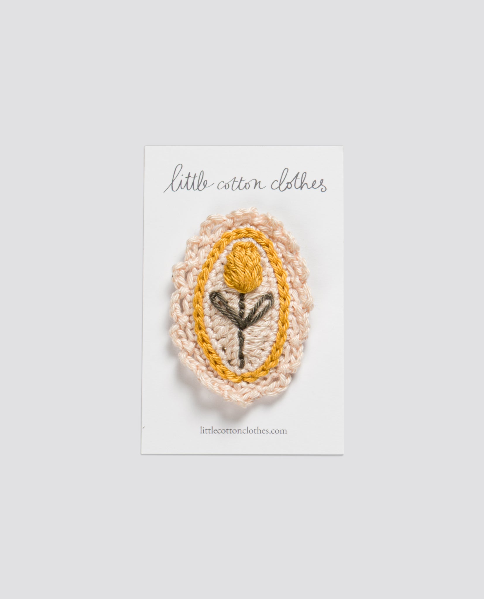 Handcrafted crochet hair clip featuring a yellow tulip design, made with natural cotton yarn, reflecting a vintage and sustainable style for children.