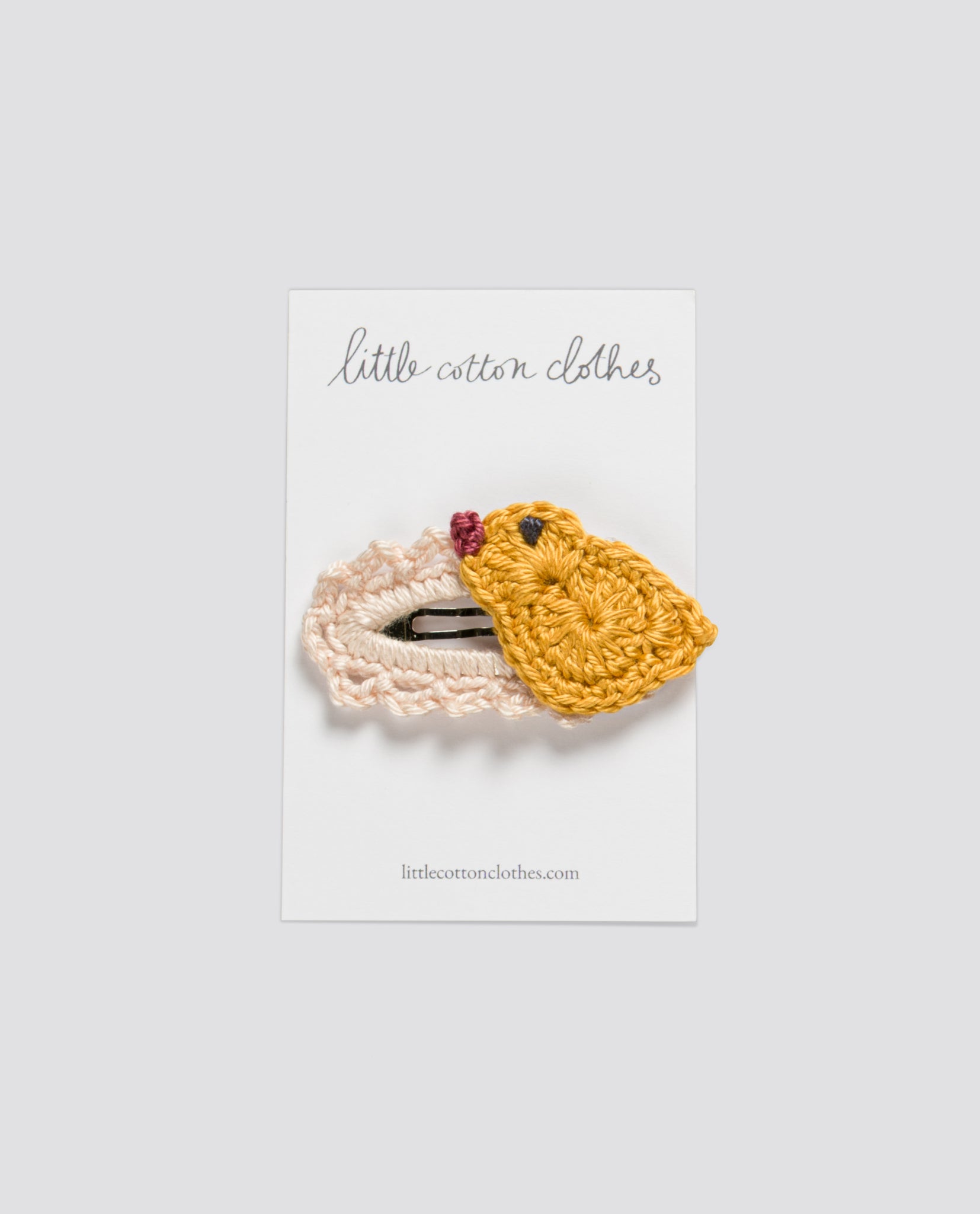 Small crochet hair clip for kids shaped like a yellow chick, handmade with natural cotton, reflecting a vintage and sustainable style for children's clothing.