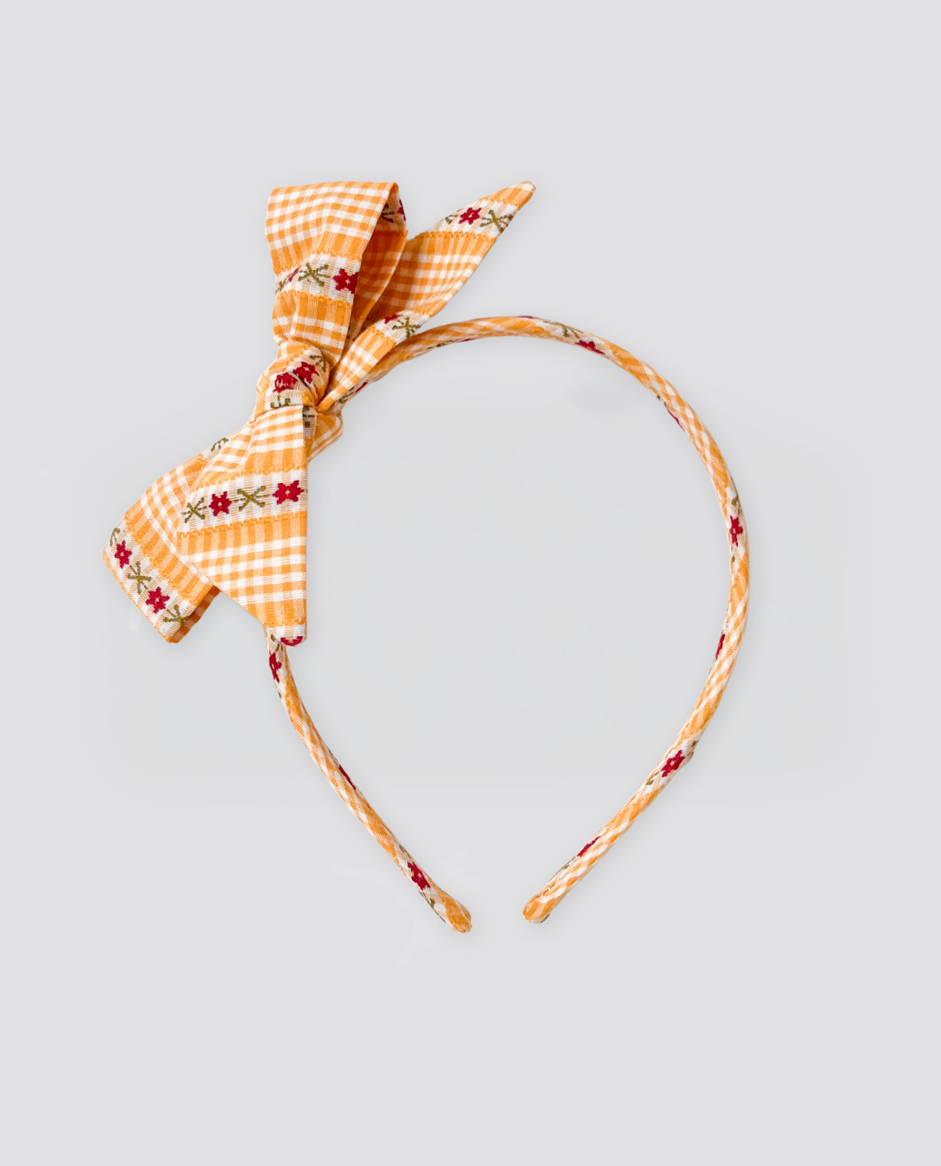 Children’s retro-style alice band in warm buttercup yellow with floral embroidery and gingham pattern, crafted from natural cotton for a vintage look.