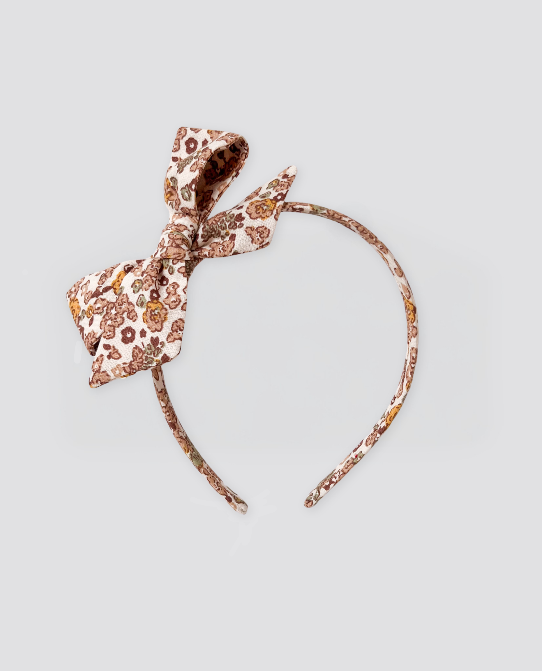 Vintage style children's floral alice band with a soft organic cotton fabric in natural tones, designed for sustainable and ethical kids clothing.