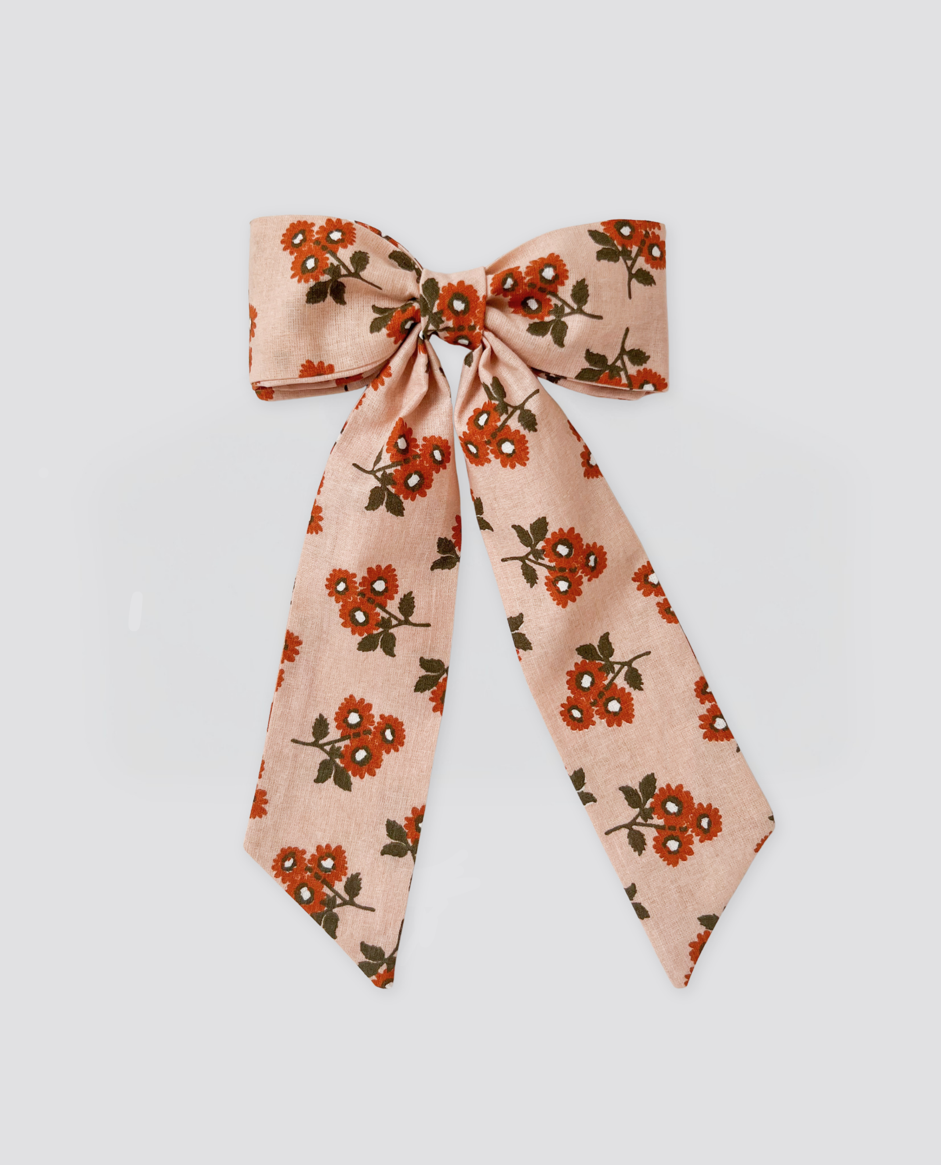 Soft fabric bow clip in marigold floral pattern with vintage-inspired design, crafted from organic cotton for a natural, slow, and ethical children's accessory.