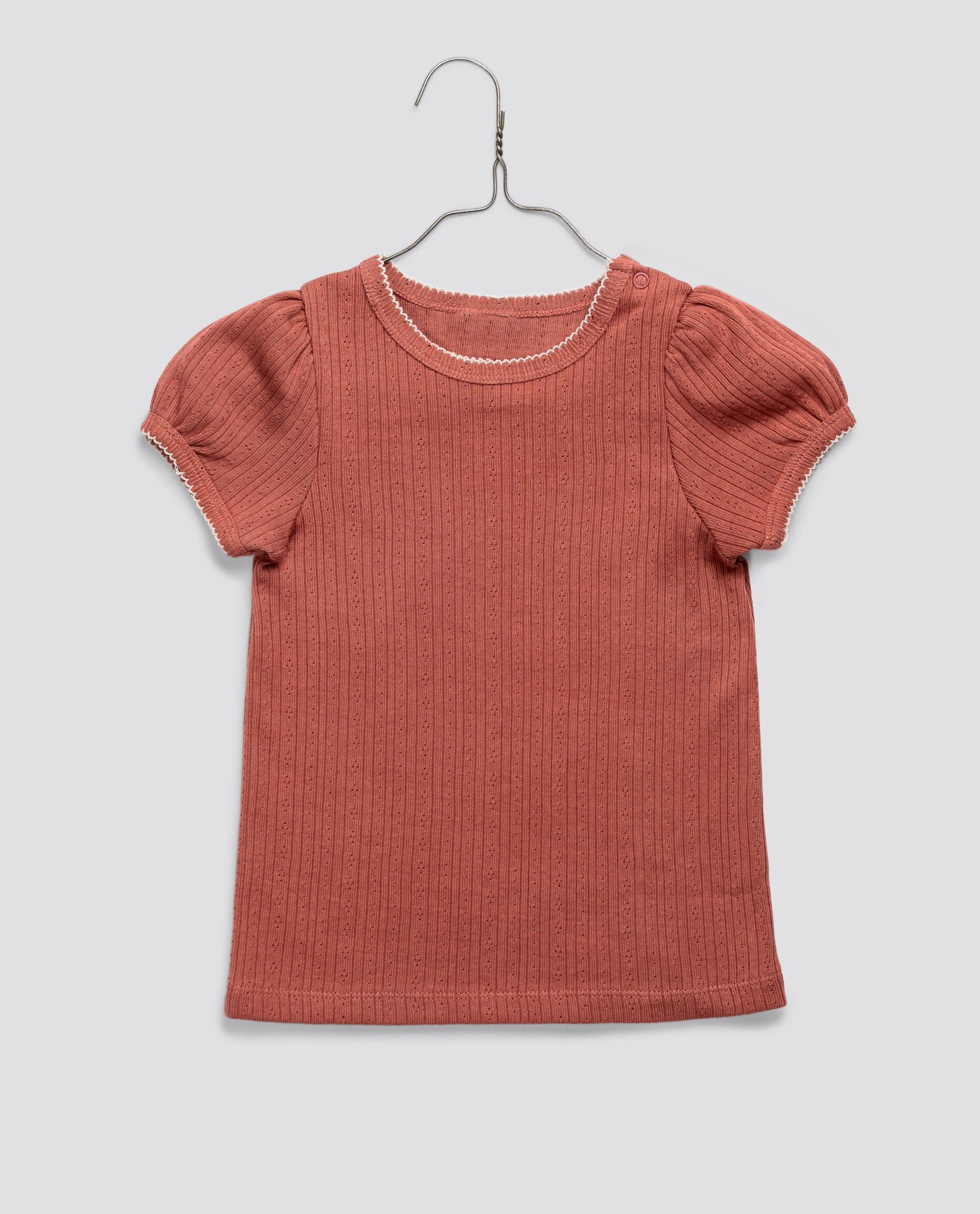 Pink organic cotton girls tshirt with delicate pointelle pattern and puff sleeves, featuring a vintage-inspired, sustainable design for ethical children's clothing.