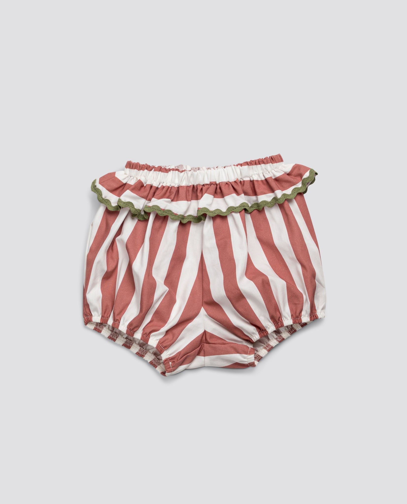 Pink and white striped frilly bloomers for babies and toddlers made from soft organic cotton with a vintage-inspired ruffle trimmed in green, designed with sustainable care.