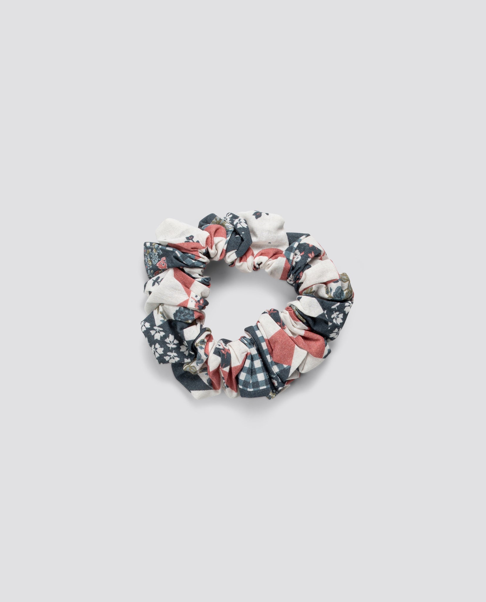 Scrunchie with a vintage patchwork floral pattern made from organic cotton, reflecting a slow, natural, and ethical approach to children's accessories.