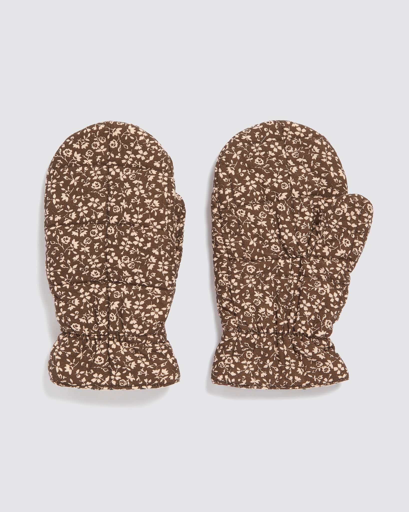 Pair of brown quilted mittens with beige floral pattern for kids, made from organic cotton, featuring a vintage style and sustainable, ethical craftsmanship.