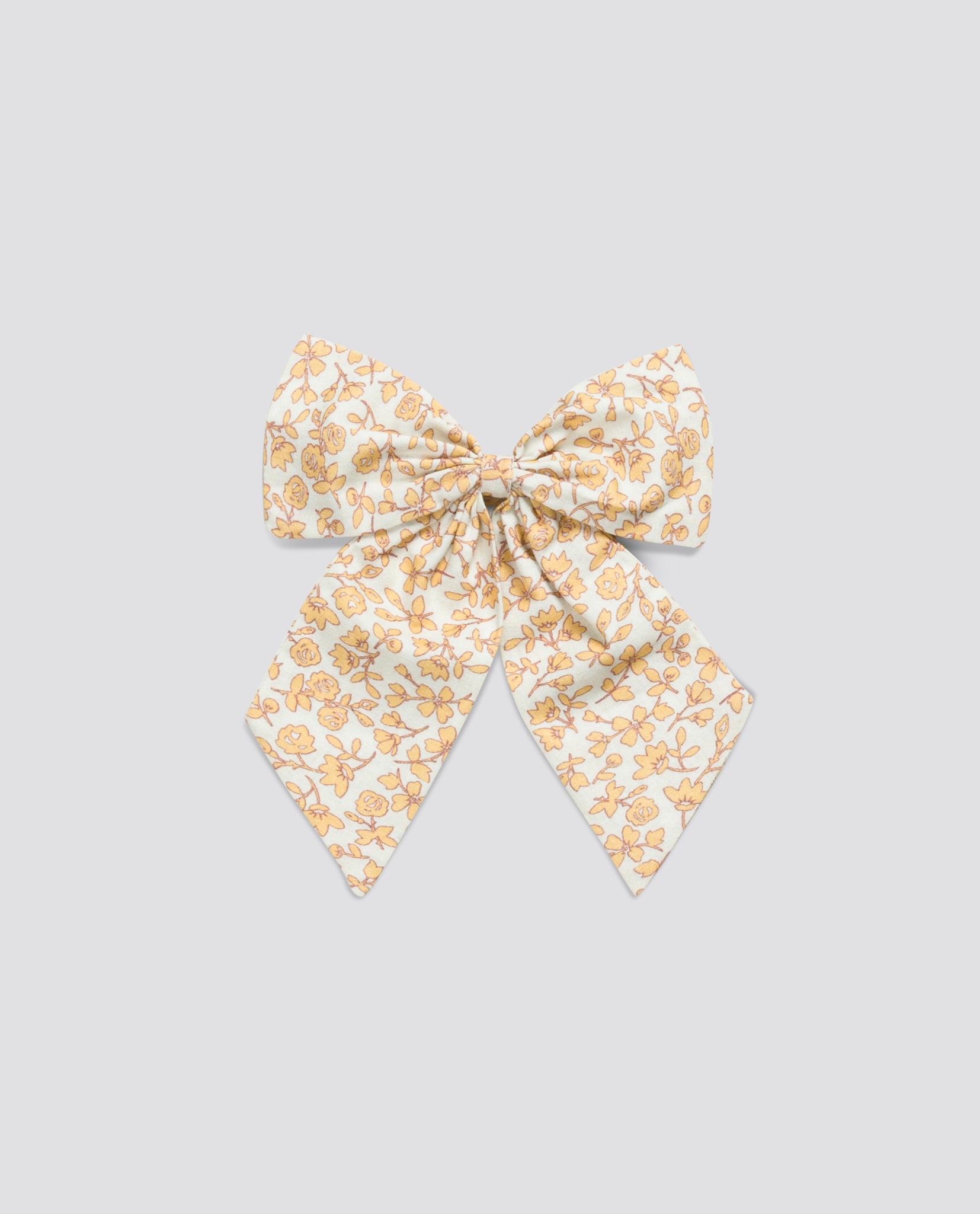 Vintage-style girls hair bow with soft elastic, featuring a delicate floral pattern in warm tones, made from natural, organic cotton for ethical children's clothing.