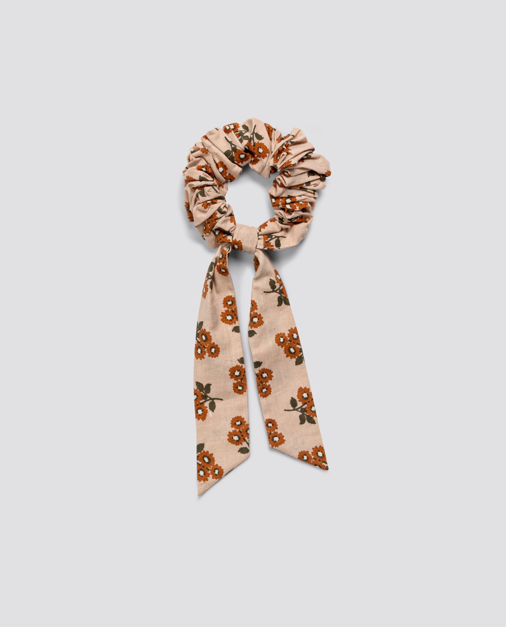 Organic cotton scrunchie with a marigold floral pattern and bow detail, crafted in a sustainable and ethical vintage style for children's accessories.