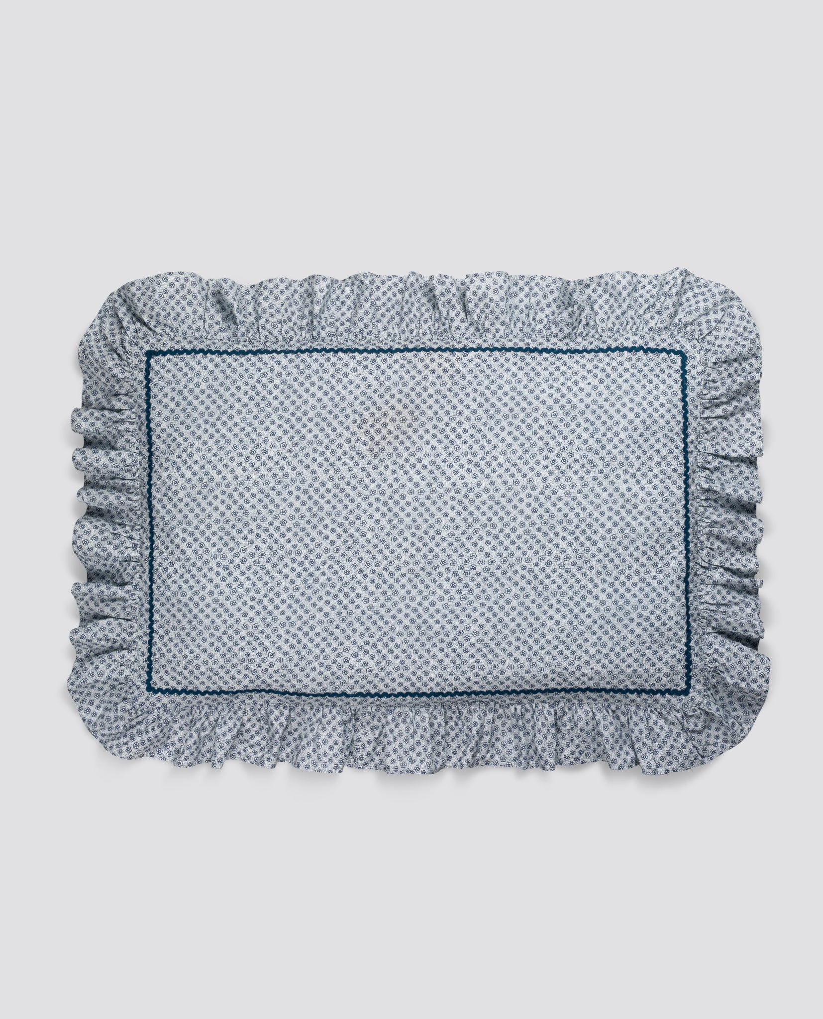 Soft cotton pillowcase with delicate blue floral print and ruffled edges, crafted from natural materials for a gentle, vintage-inspired children's bedroom.