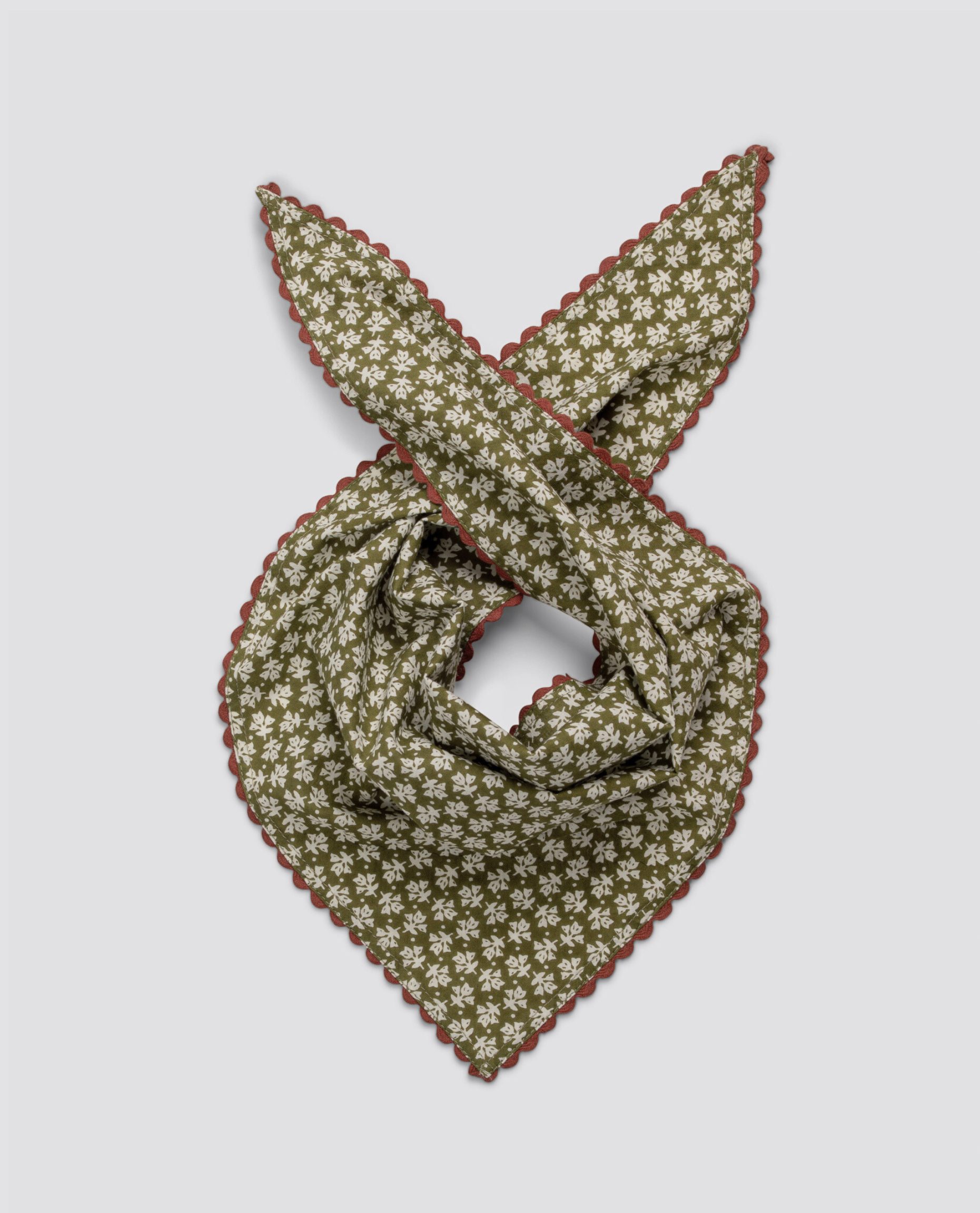 Olive green floral scarf with white vintage-style flowers and scalloped brown edge, made from organic cotton, embodying sustainable and ethical children's fashion.