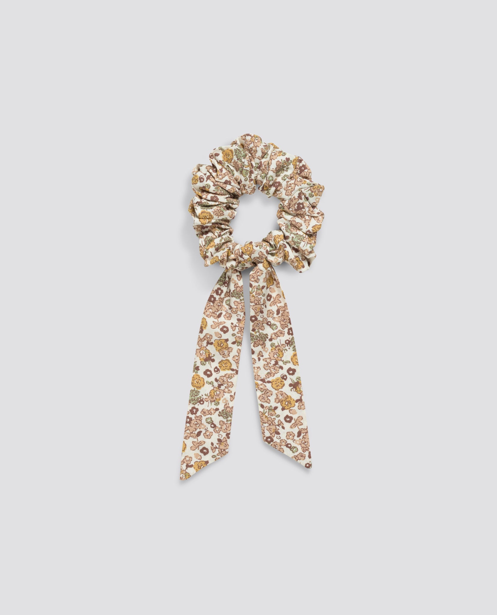 Floral scrunchie with bow detail made from organic cotton, featuring a soft vintage-inspired pattern in natural tones, perfect for ethical children's style.