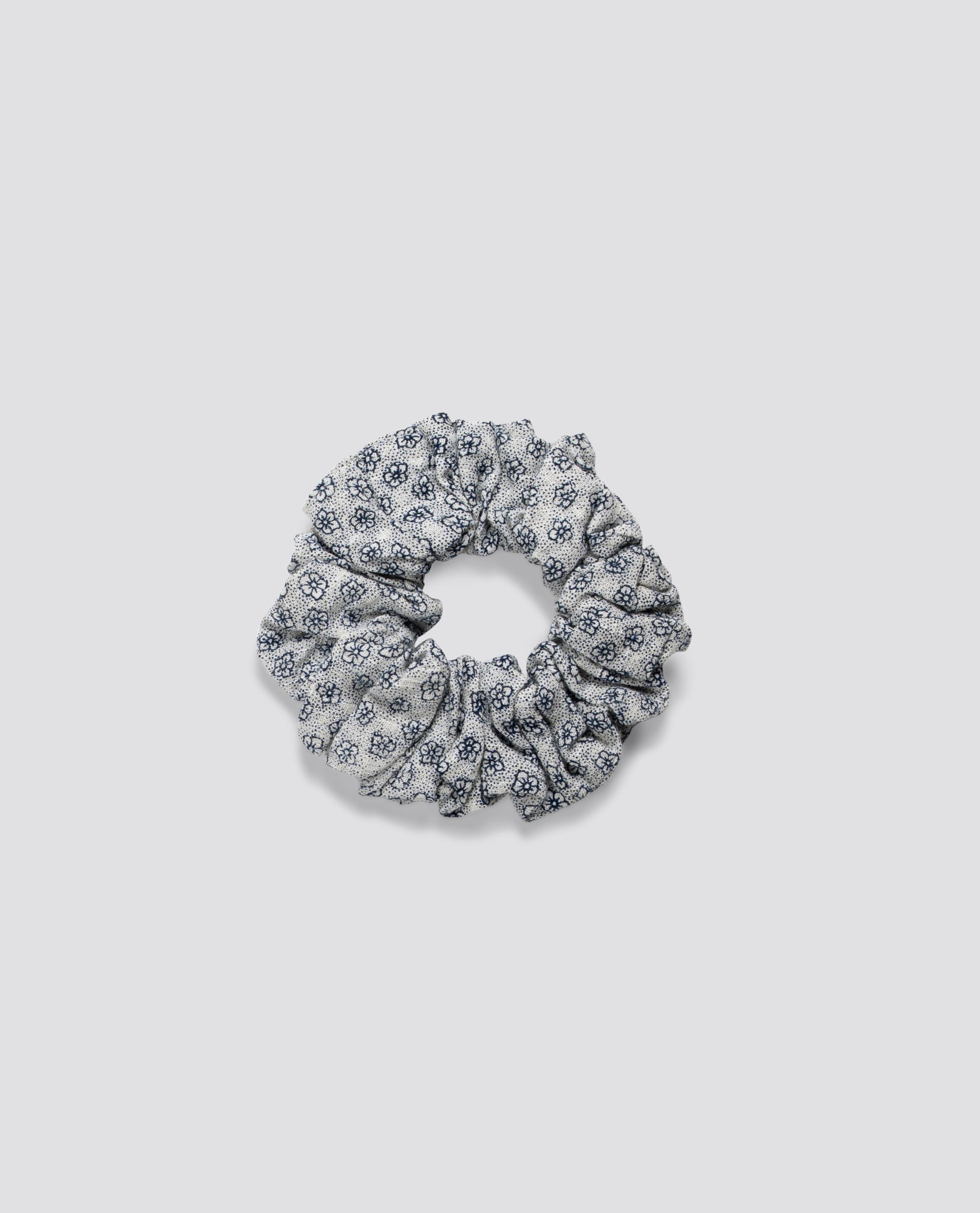 Soft scrunchie made from organic cotton with a delicate vintage-inspired floral pattern, perfect for adding a charming touch to children's hairstyles.