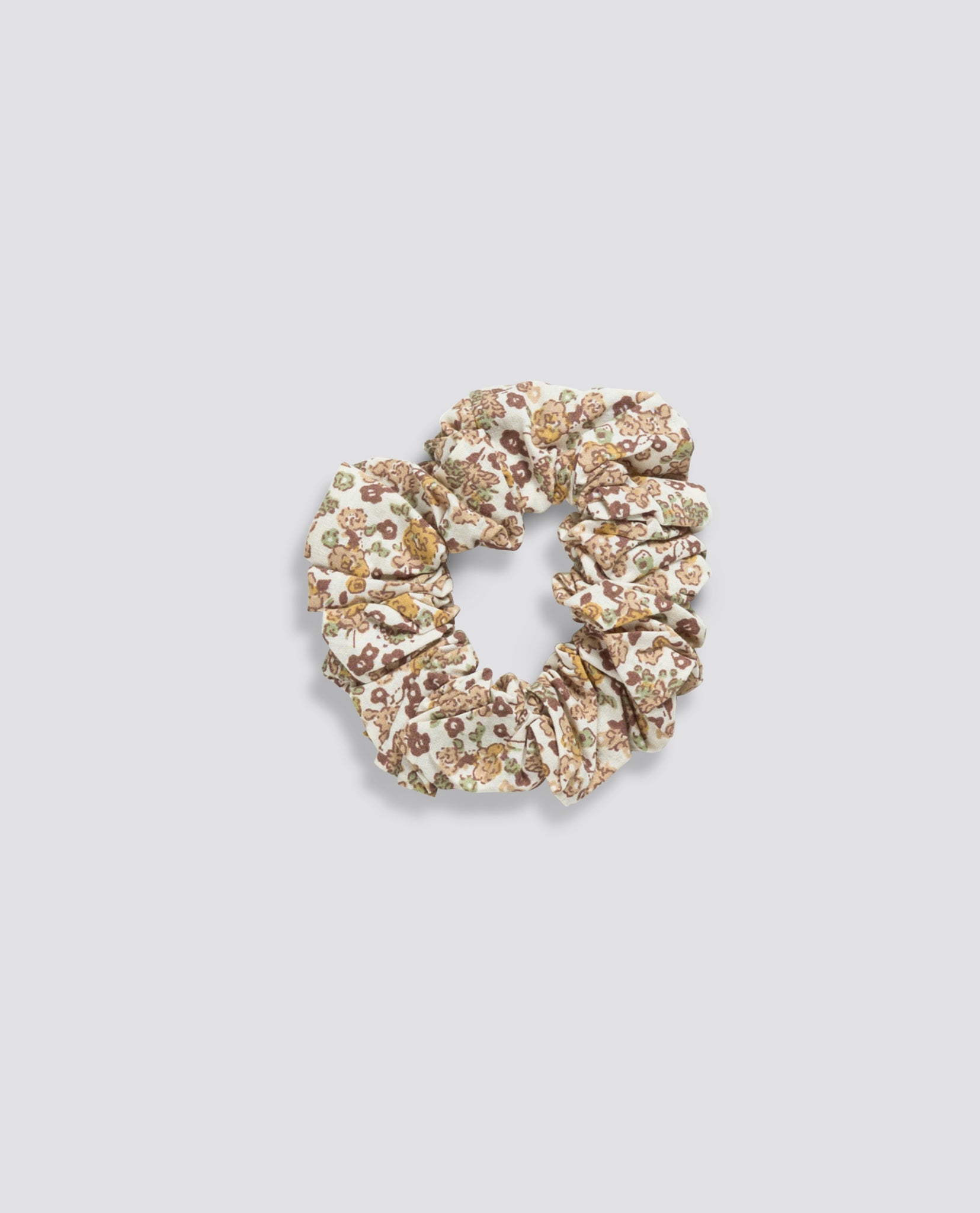 Organic cotton scrunchie with a vintage-inspired floral pattern in soft, natural tones, designed for a gentle, sustainable addition to children's accessories.