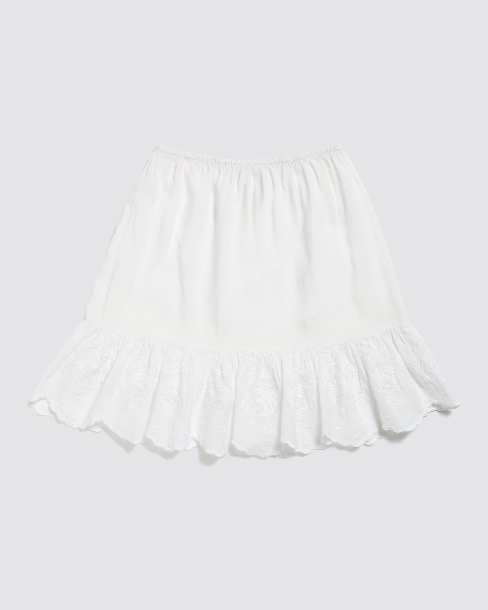 White scalloped petticoat for kids made from organic cotton, featuring delicate broderie anglaise trim, perfect for vintage-style, sustainable children's clothing.