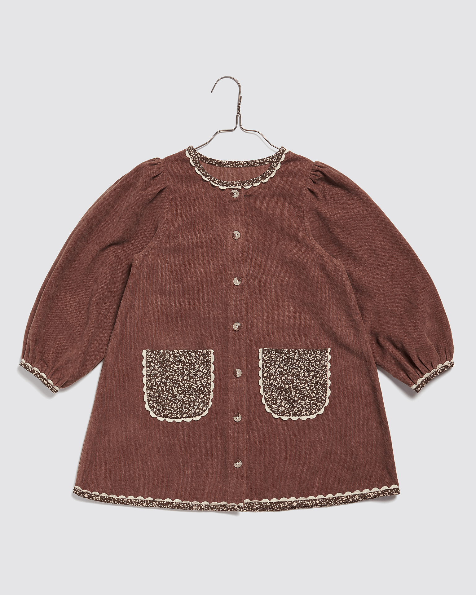 Vintage style girls dress in nutmeg velvet with floral organic cotton pockets and trim, designed with sustainable, ethical materials for slow, natural children's clothing.