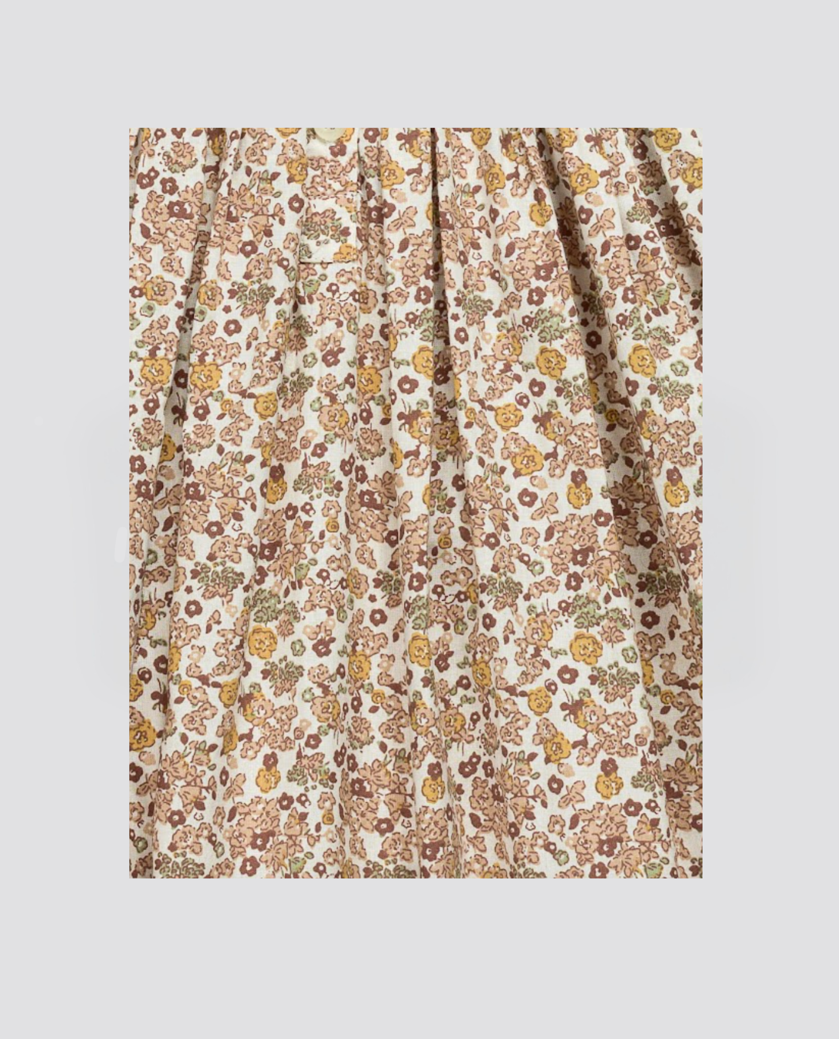 Close-up of natural organic cotton fabric with delicate vintage-style yarrow floral pattern in muted earth tones, perfect for ethically made children's clothing.
