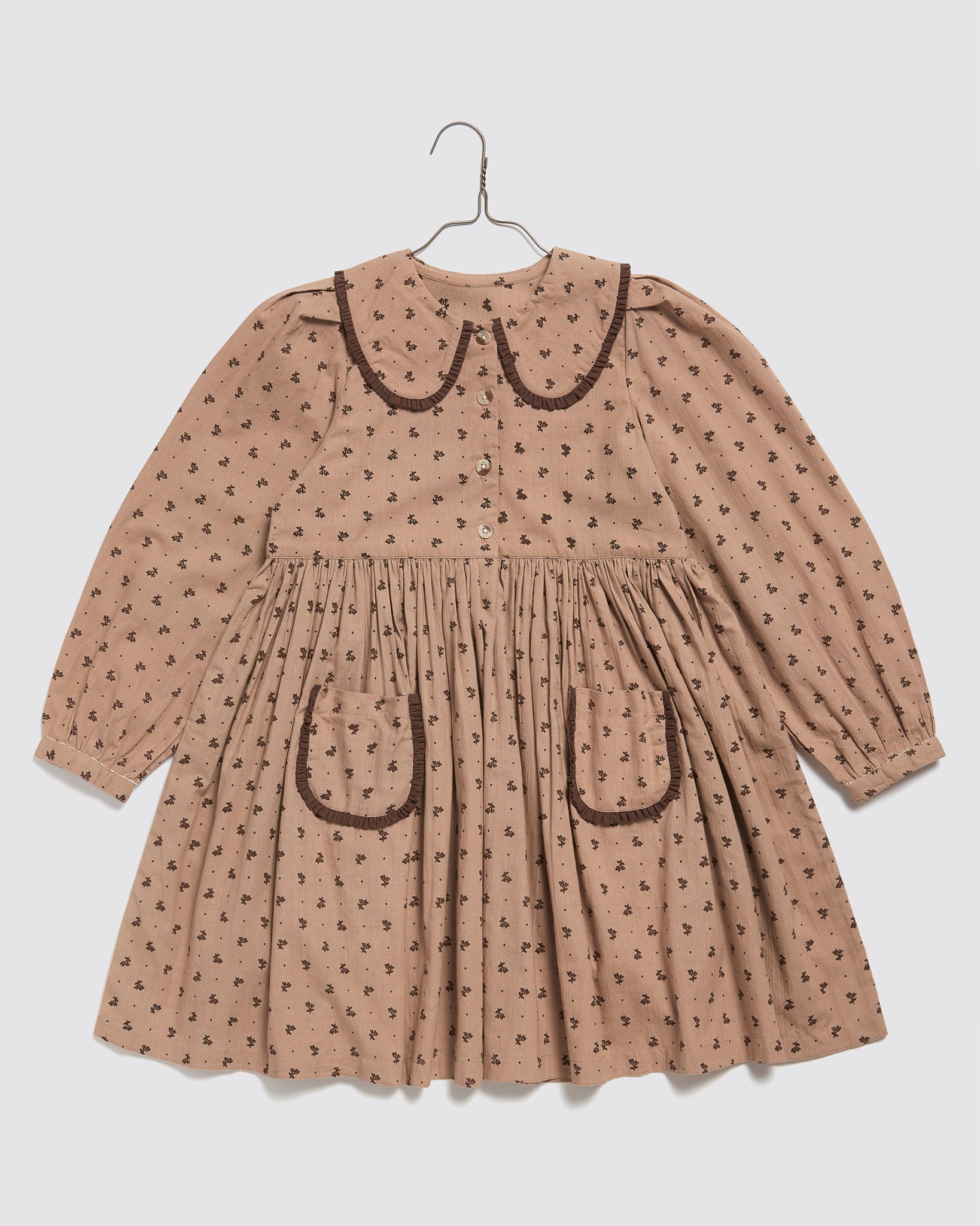 Vintage style girls dress in pink rosehip floral organic cotton with long sleeves, a rounded collar, and two front pockets, ethically made for kids.