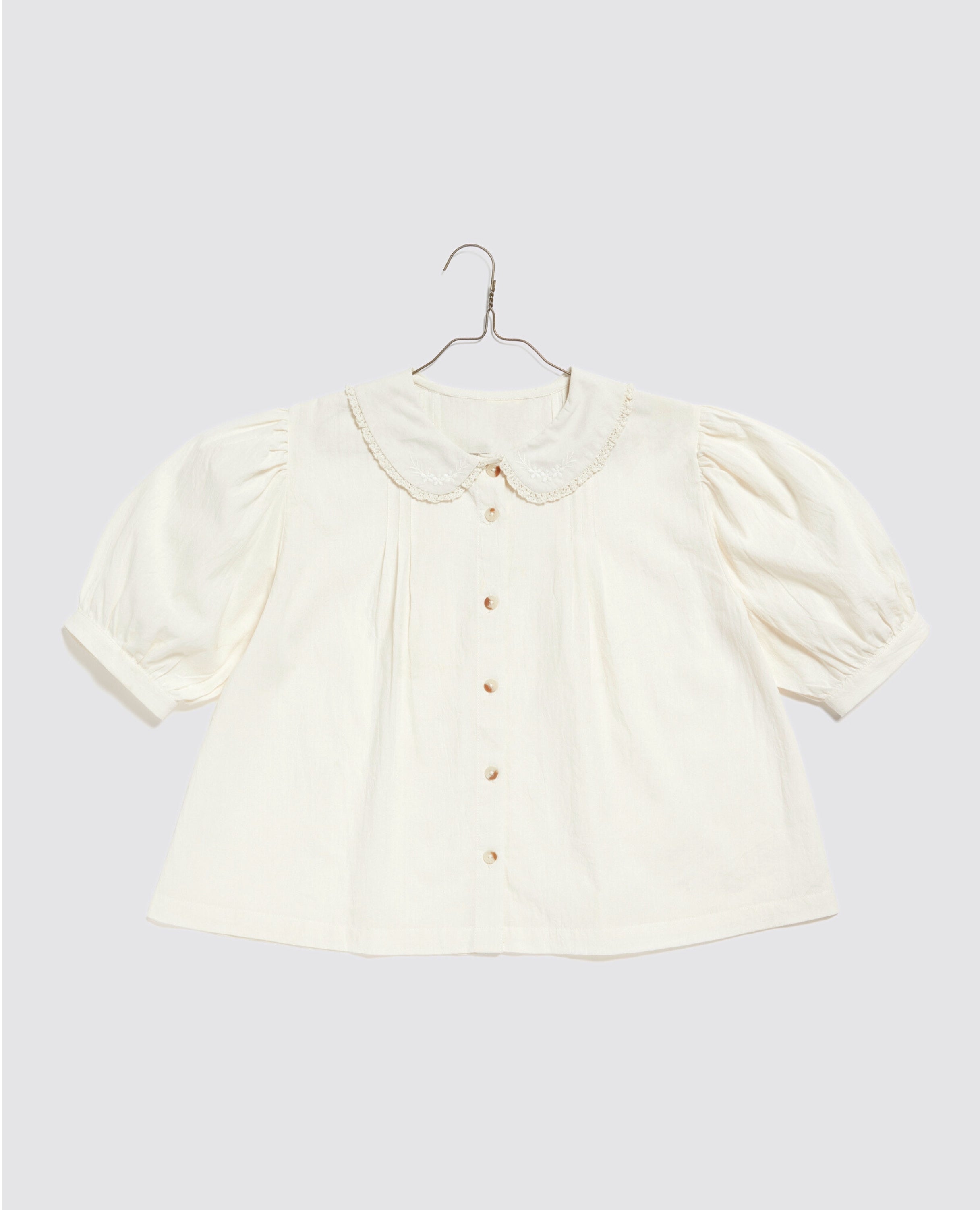 White cotton blouse with puffed sleeves and a delicate scalloped collar, showcasing a vintage-inspired, natural, and ethically made design for a slow, sustainable wardrobe.