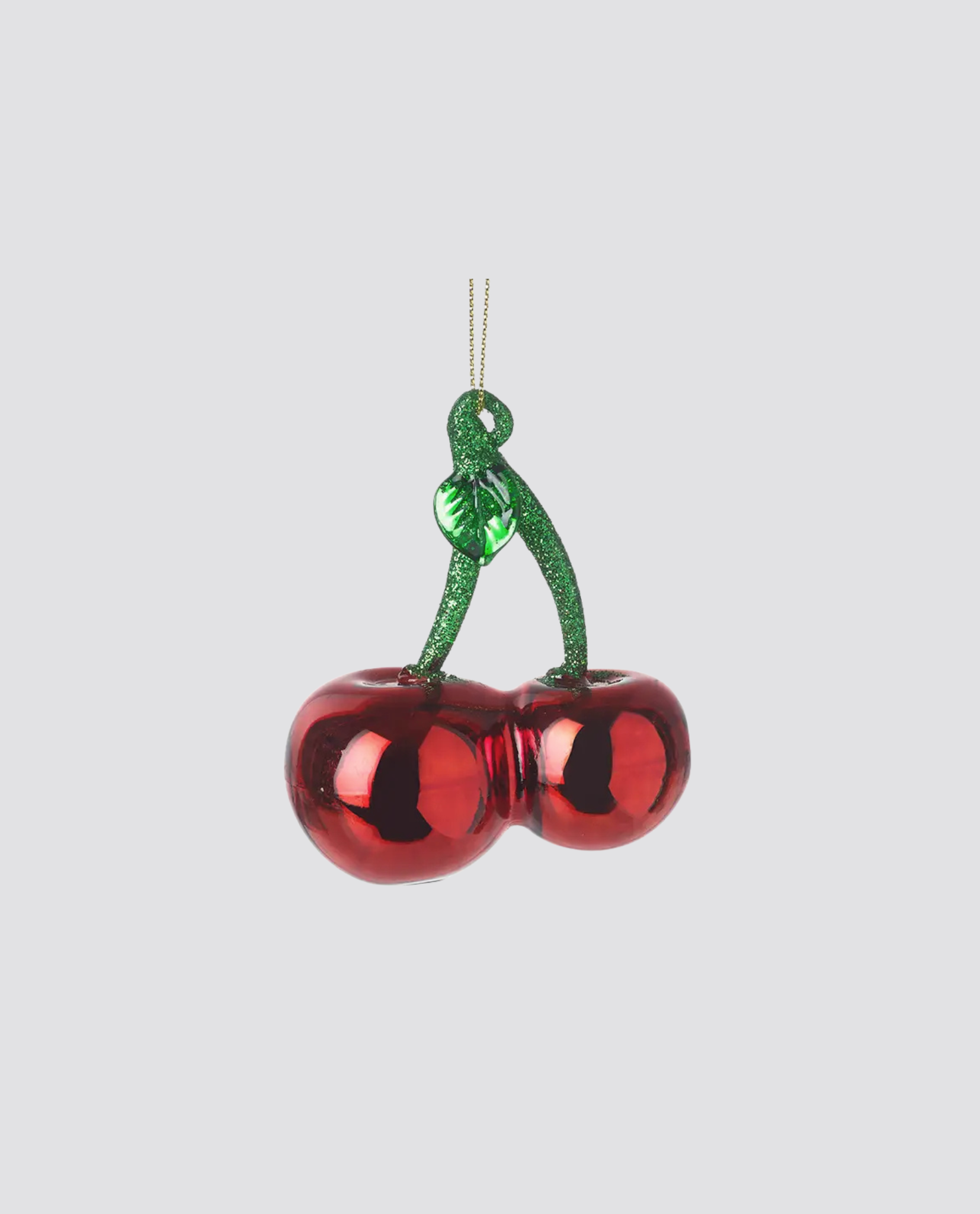 Shiny red glass cherries decoration with green glittery stem and leaf, reflecting a vintage, natural style perfect for adding a charming, organic touch to home decor.