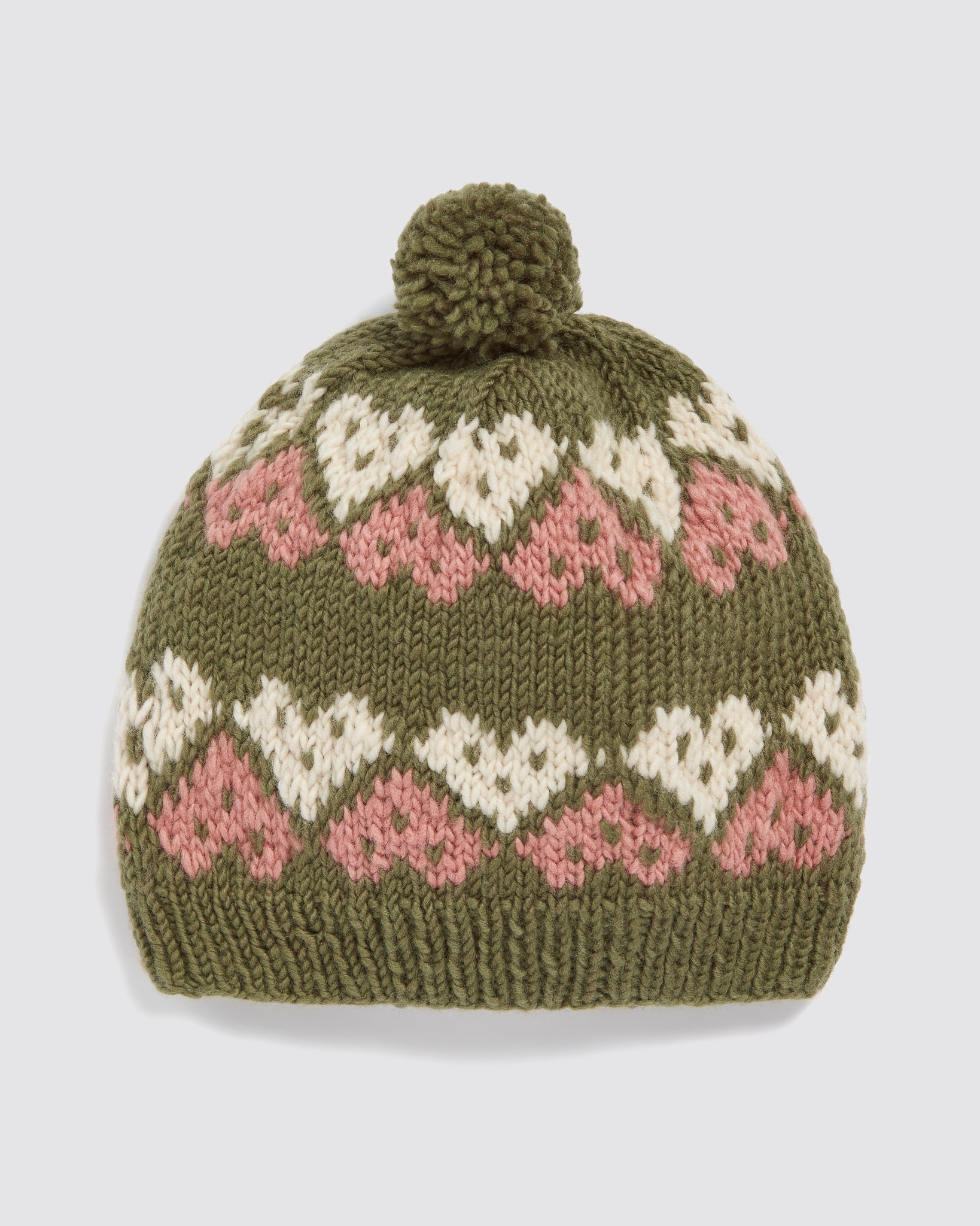 Hand-knitted children’s bobble hat made from soft merino wool in multicolor with pink and cream heart patterns, reflecting vintage style and sustainable craftsmanship.