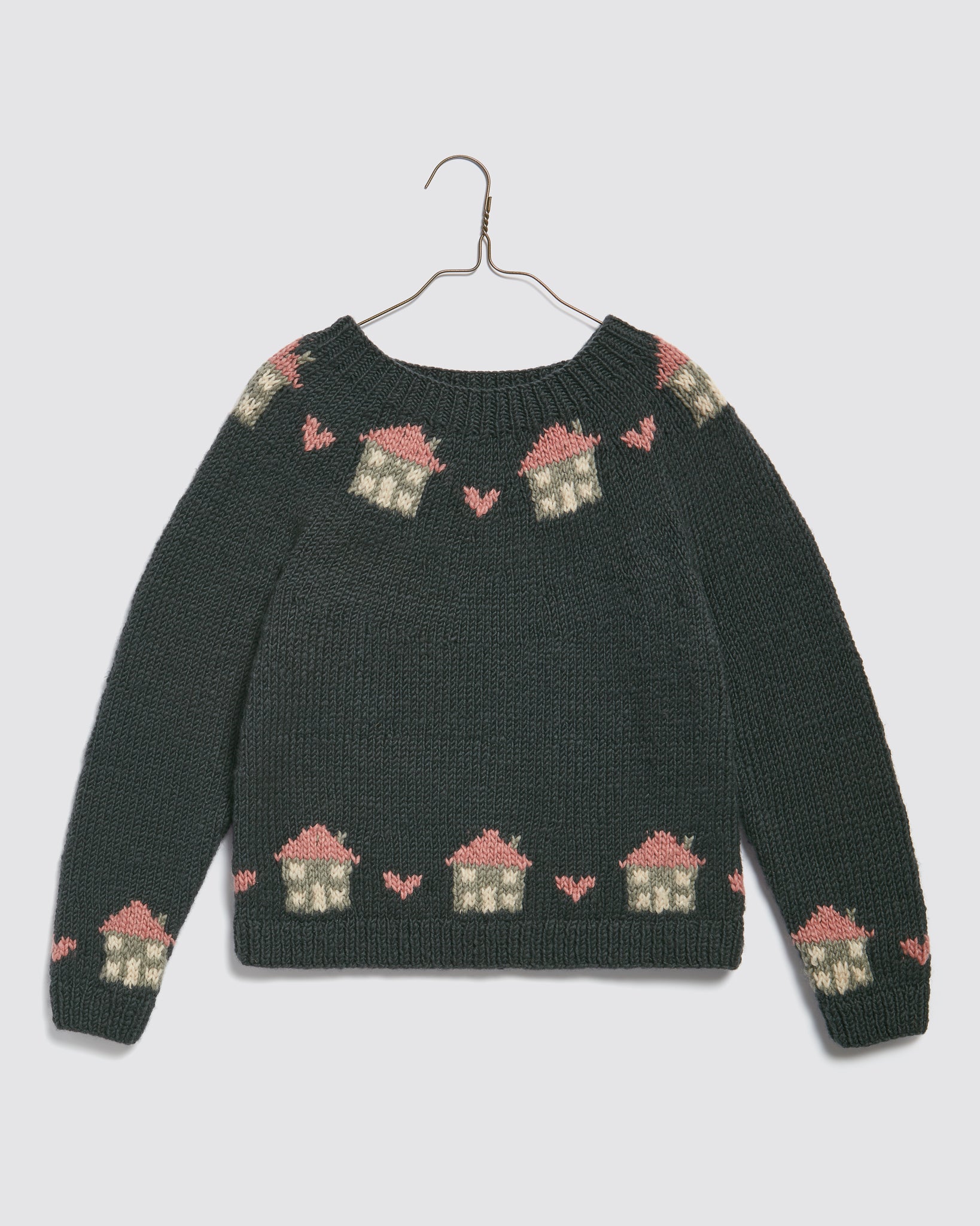 Dark green hand-knitted merino wool jumper for kids featuring a vintage-style cottage and heart pattern, made from sustainable natural materials with a cozy fit.
