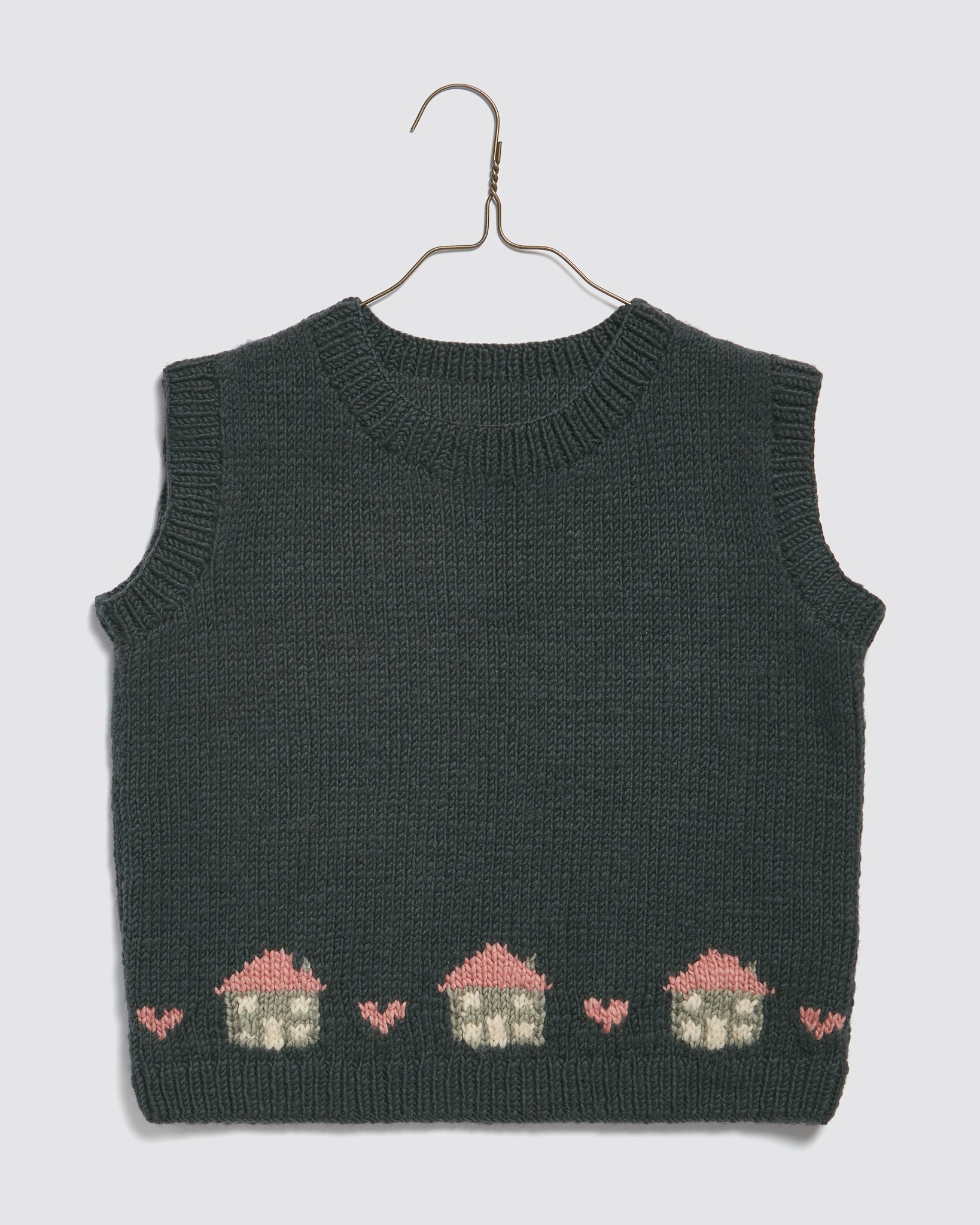 Dark green hand-knitted merino vest for kids featuring a charming vintage-style cottage pattern, made with natural, organic materials for sustainable children's clothing.