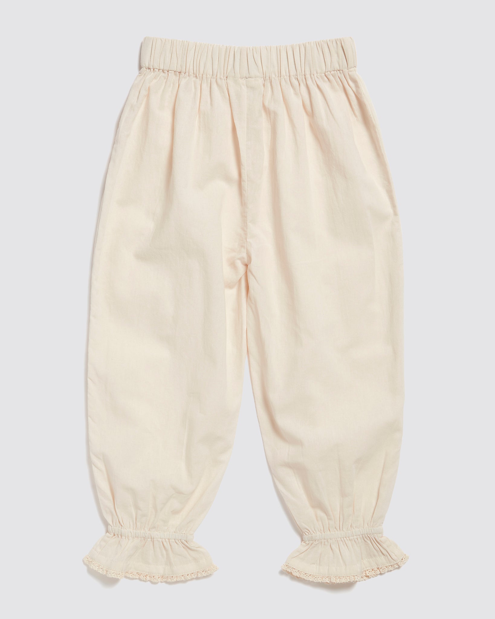 Soft dew-colored children's trousers made from organic cotton with delicate vintage-inspired ruffle cuffs, designed for sustainable and ethical wear.