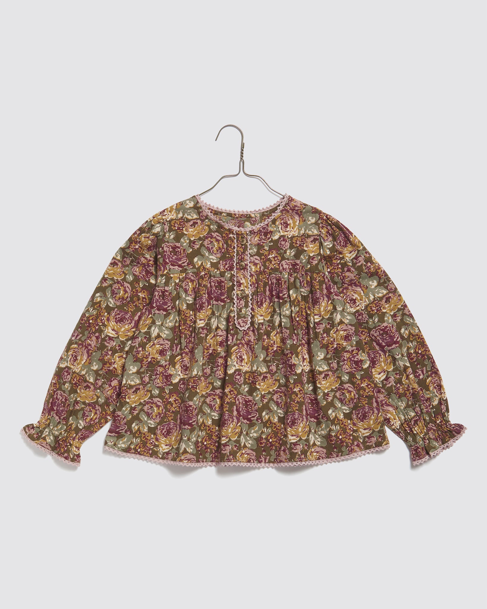 Vintage style girls blouse in organic cotton with a delicate floral print, featuring long sleeves and soft natural tones for sustainable children's clothing.