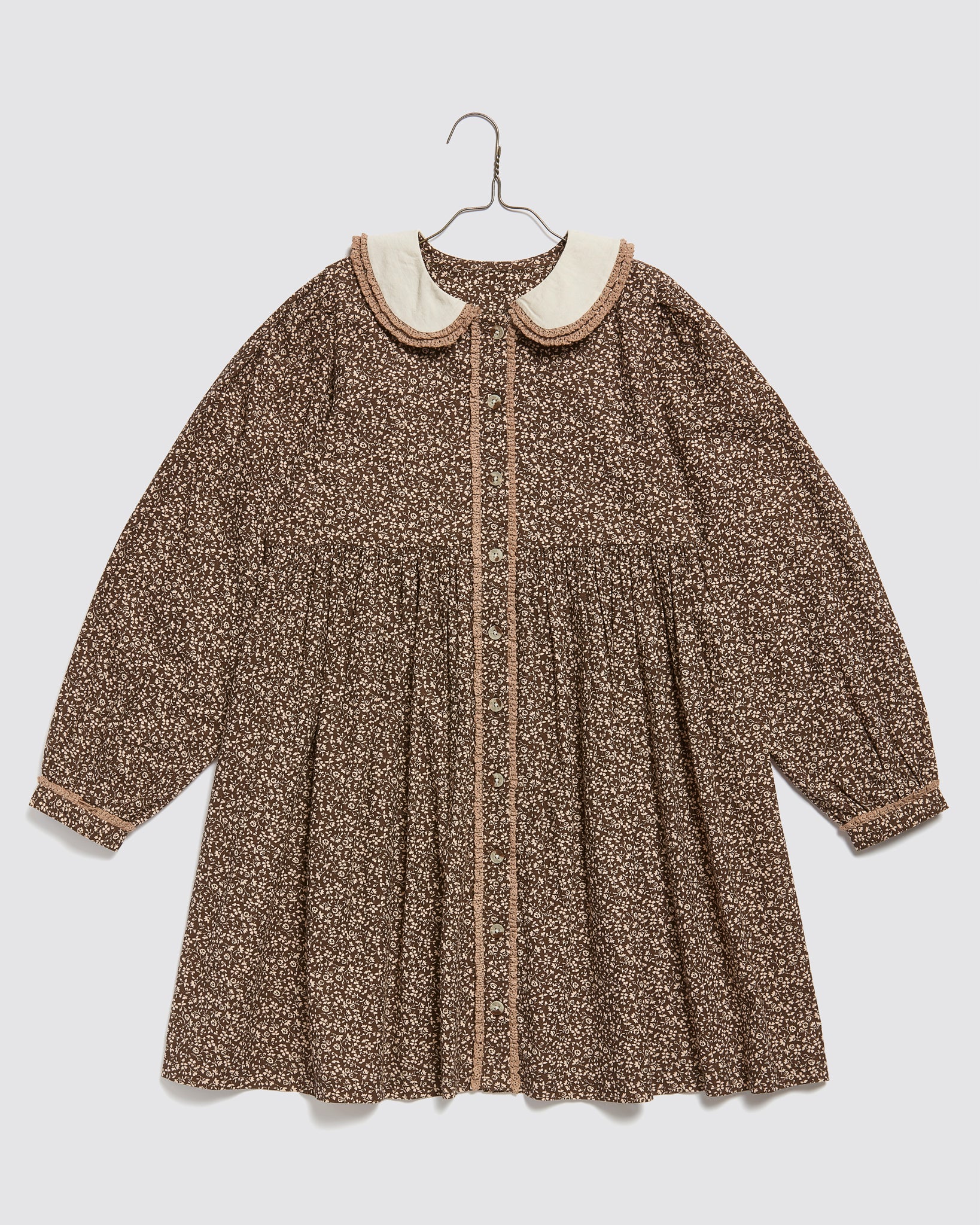 Brown, beige, and cream floral organic cotton girls dress with long sleeves, vintage-inspired peter pan collar, and delicate button details, designed for sustainable kids clothing.