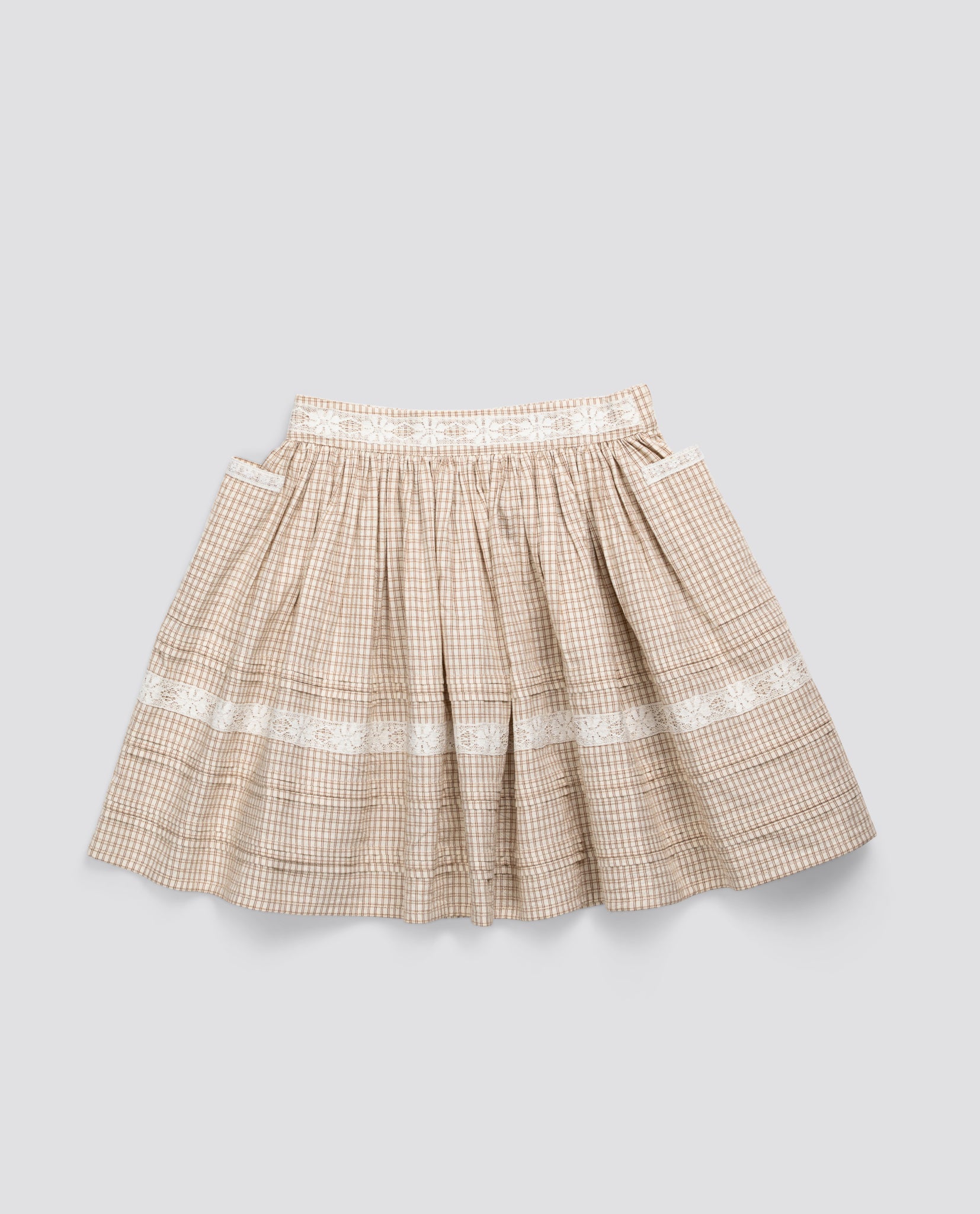 Cream checkered skirt for kids made from soft organic cotton with vintage-inspired detailing, offering a sustainable and ethically made option in children’s clothing.