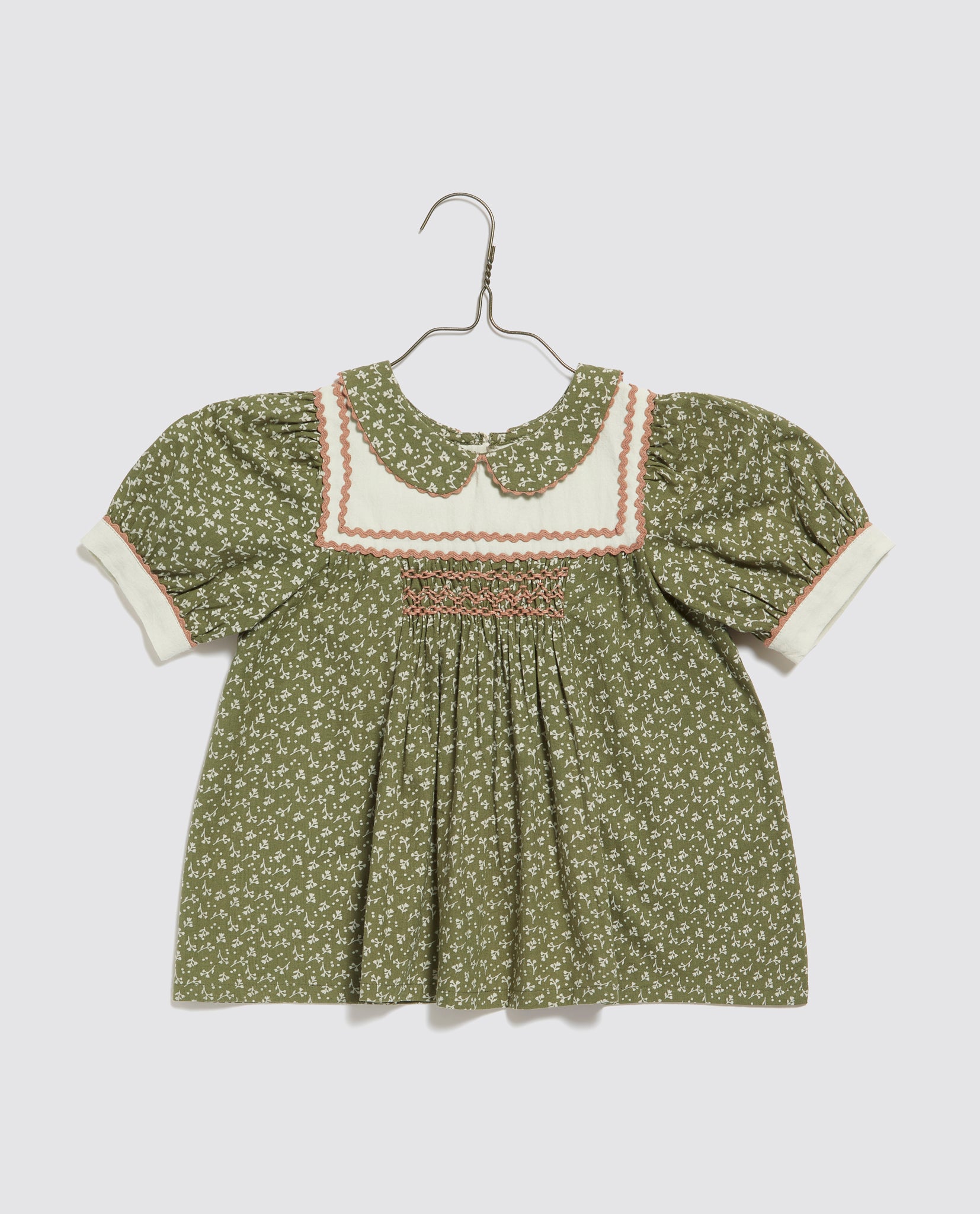 Vintage style girls cotton blouse in green with delicate floral print, smocked detailing, and puff sleeves, crafted sustainably with natural materials for ethical children’s wear.