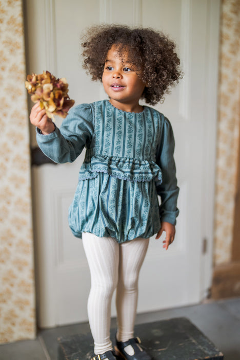 Vintage inspired, teal and Blue floral romper, with frill at the waist finished with gathered trim. Buttons to the back and elastic to the legs. 3