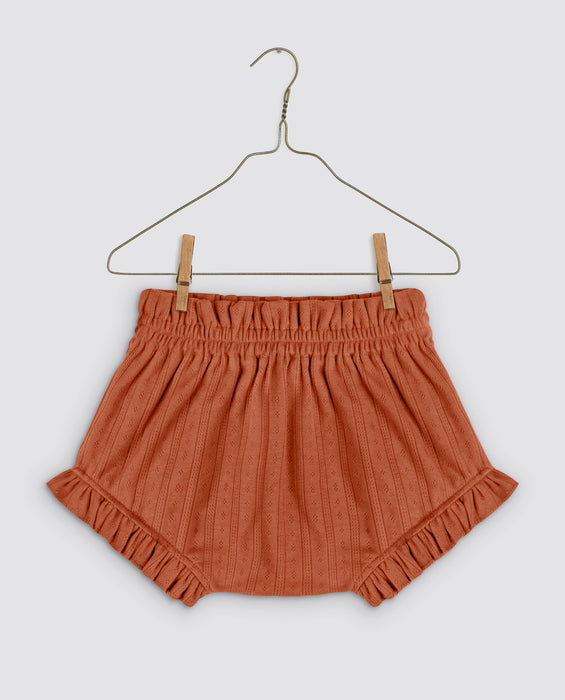 Baby bloomers with leg frills and paper-bag waist. Made in soft organic jersey pointelle in the colour pecan.