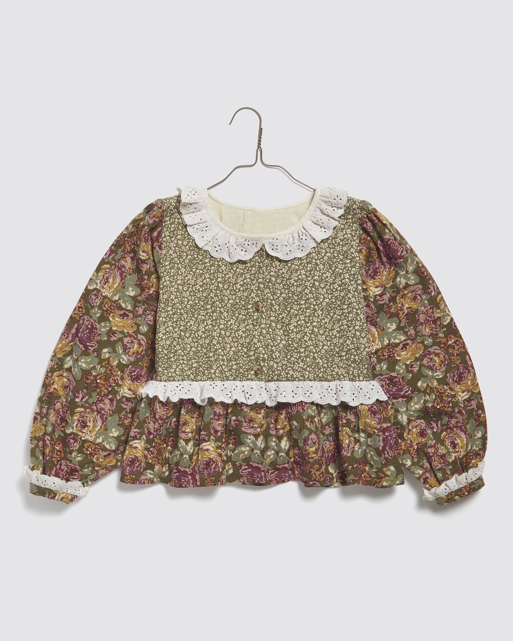 Girls vintage style blouse in organic cotton featuring a green and pink floral pattern with delicate lace trim, designed for comfortable and sustainable kids clothing.
