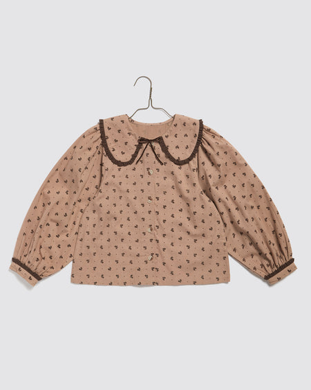 Our pretty girl's blouse is made in our organic, floral fabric. It has an oversized collar with gathered fabric frill and full sleeves with button-up cuffs. 