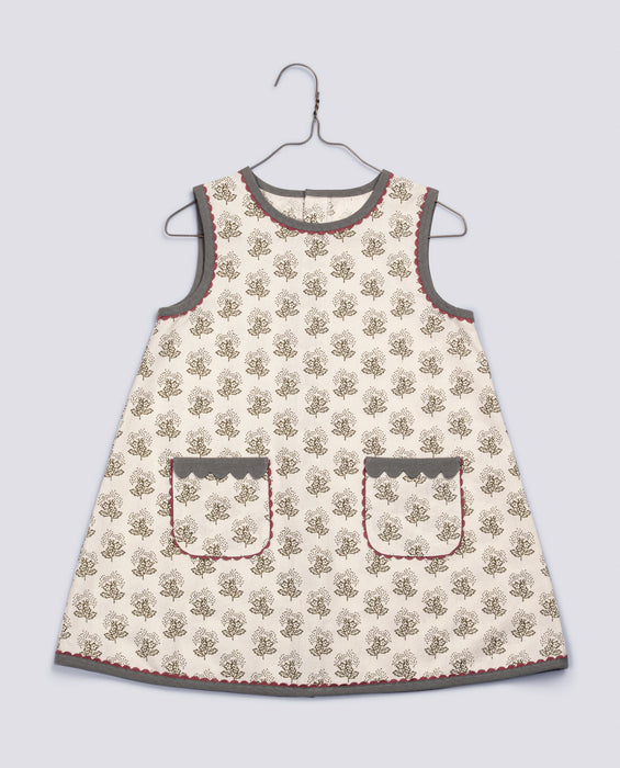 Retro style A-line girl's dress in organic, white floral cotton fabric. contrasting binding and scalloped edging to pockets. Pink cotton ric rac trim. 