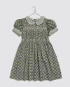 Vintage inspired children's party dress. Hand smocking, puff sleeves and Peter Pan collar. Blue floral printed cotton with ric-rac trim.