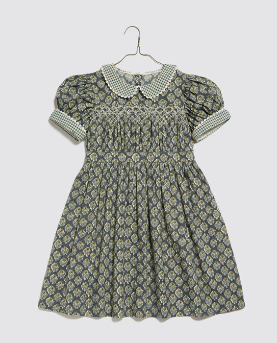 Vintage inspired children's party dress. Hand smocking, puff sleeves and Peter Pan collar. Blue floral printed cotton with ric-rac trim.
